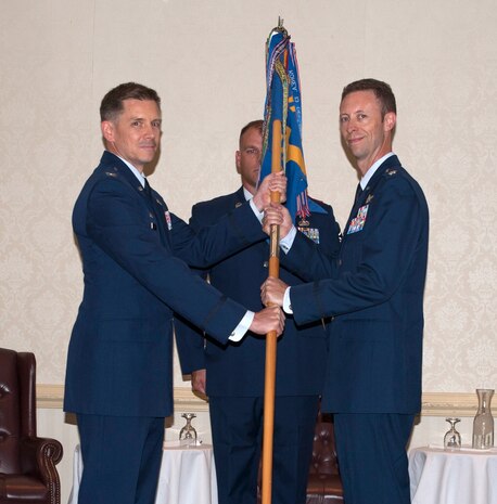 Colonel Trevor Nitz, 437th Operations Group commander, passes the squadron guidon to Lt. Col. Joseph Meyer, 14th Airlift Squadron incoming commander, during the 14th AS change of command ceremony at Joint Base Charleston - Air Base, S.C., Sept. 17, 2012. (U.S. Air Force photo/Airman 1st Class Ashlee Galloway)