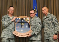 Master Sgt. Patrick Michaels, 319th Security Forces First Sergeant, and Senior Master Sgt. Mark Cantrell, 319th SFS manager, present Staff Sgt. Kristoffer Schneider, 319th Security Forces patrolman, with a shadow box commemorating his military service during a special retirement ceremony Sept. 14, 2012, at Grand Forks Air Force Base, N.D. (U.S. Air Force photo/Senior Airman Amber Bennett)