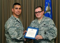 Lt. Col. Frank Reyes, 319th Security Forces Commander, presents Staff Sgt. Kristoffer Schneider, 319th Security Force patrolman, with a letter of appreciation, Sept. 14, 2012, Grand Forks Air Force Base, N.D. Schneider was recognized during a special retirement ceremony. (U.S. Air Force photo by Senior Airman/Amber Bennett)