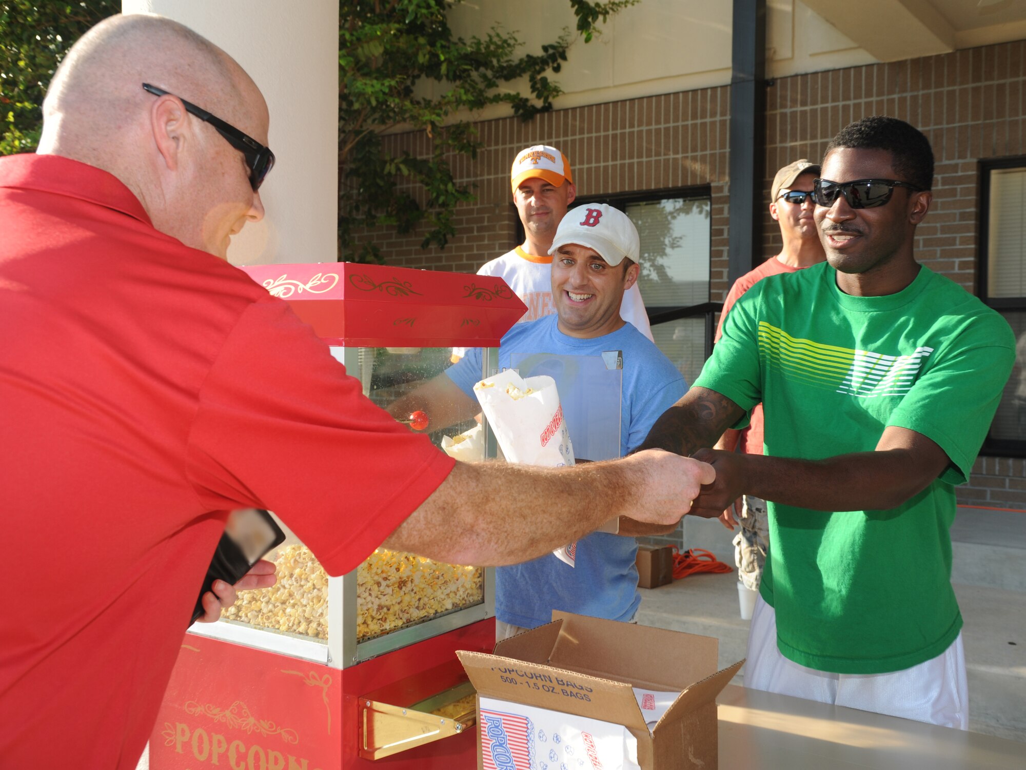 Chief Master Sgt. Glen Usherwood, 81st Training Group superintendant, receives a bag of popcorn from Tech. Sgt. Stephen Ensminger and Staff Sgt. Renardo Richardson, 81st Training Support Squadron, at the 65th Air Force Birthday Celebration event at the Triangle Sept. 14, 2012, at Keesler Air Force Base, Miss. The event featured live music, food, beverages, games, contests and prizes.  (U.S. Air Force photo by Kemberly Groue)