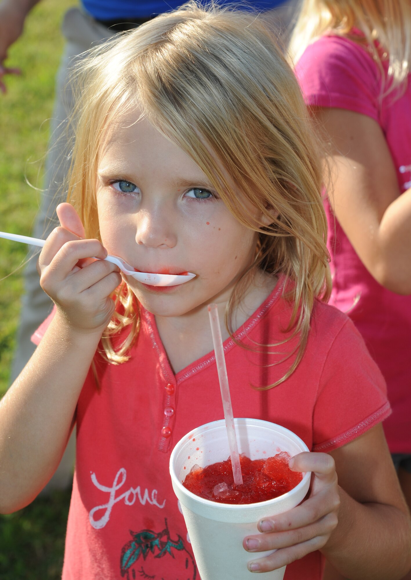 Five-year-old Cali Kirkbride, daughter of Spring and Capt. Troy Kirkbride, 81st Operations Support Flight commander, cools down with a snow ball at the 65th Air Force Birthday Celebration event at the Triangle Sept. 14, 2012, at Keesler Air Force Base, Miss. The event featured live music, food, beverages, games, contests and prizes.  (U.S. Air Force photo by Kemberly Groue)