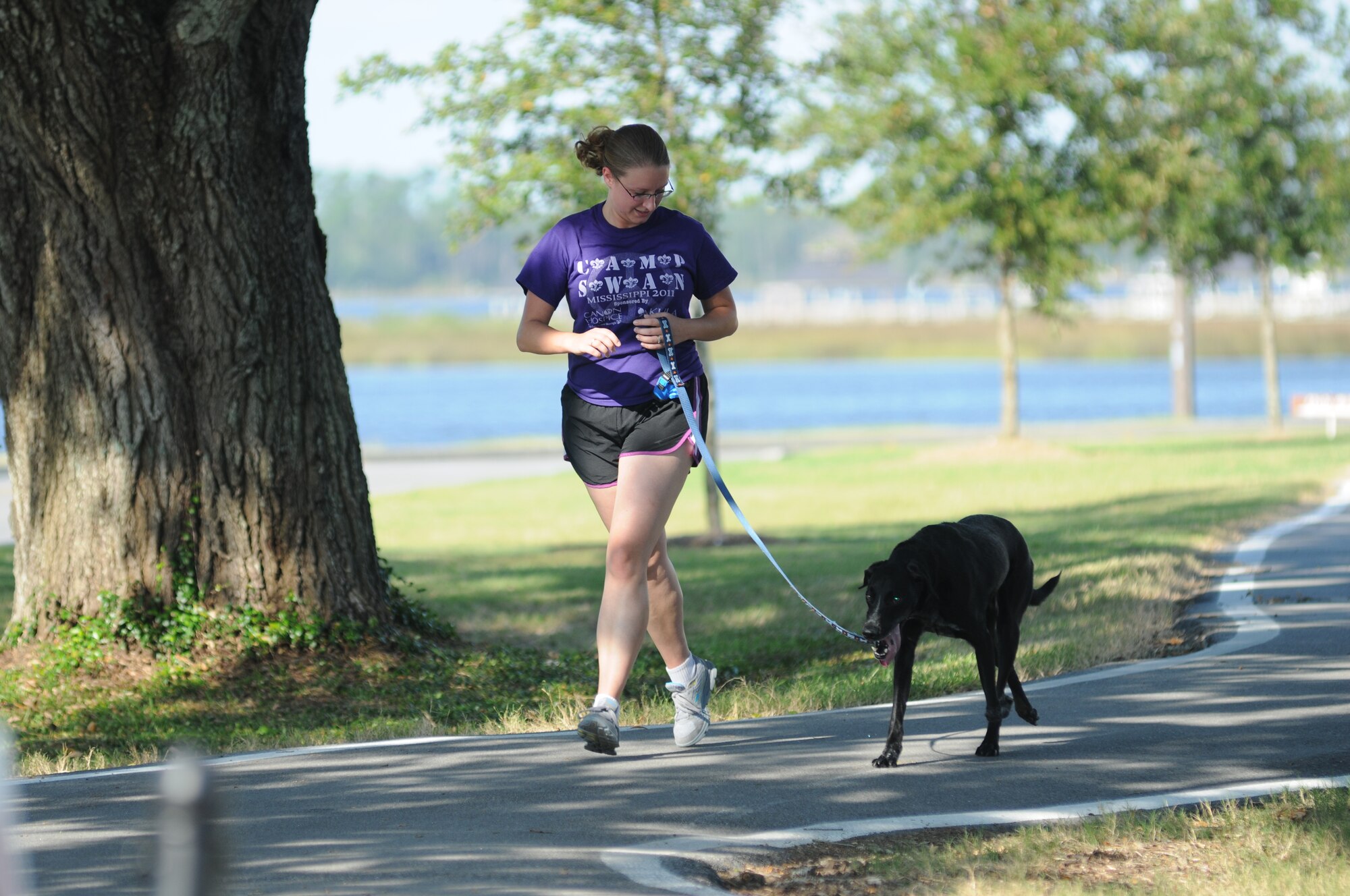 Senior Airman Amanda Nesbitt, 81st Contracting Squadron, completes a 2-mile run with her dog, Apollo, at the 5K Strut Your Mutt Fun Run event Sept. 14, 2012, at the Bay Breeze Event Center, Keesler Air Force Base, Miss.  (U.S. Air Force photo by Kemberly Groue)
