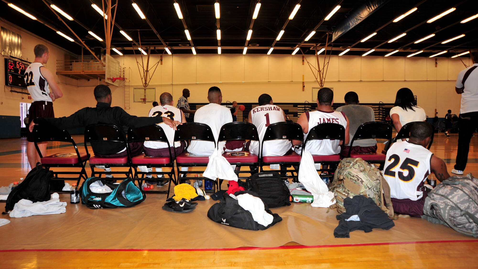 Members of the Cannon Air Force Base, N.M., men’s varsity basketball team look on as their teammates face off against varsity players from Holloman Air Force Base, N.M., at the base Fitness Center, Sept. 15, 2012. Air Commandos ended the opening game of the double feature on a high note, with a score of 79 to 71, but later tasted defeat, closing out the final game with a 12 point deficit at 54 to 66. (U.S. Air Force photo/Senior Airman Whitney Tucker)