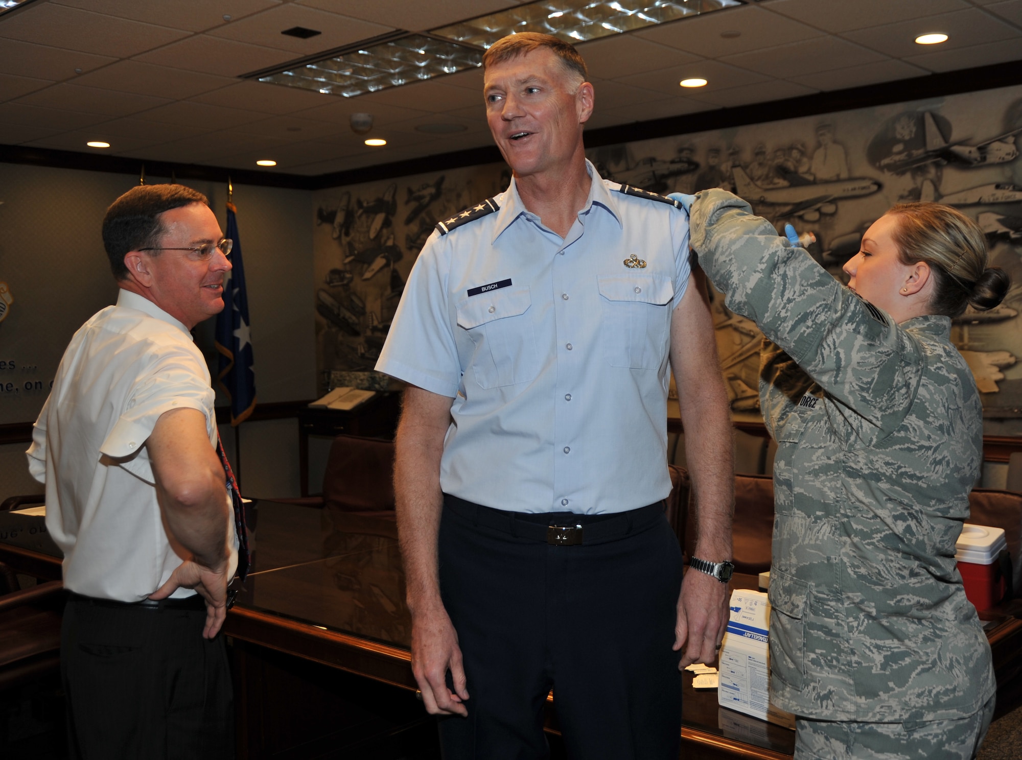 Lt. Gen. Andrew Busch, Air Force Materiel Command vice commander, receives a flu shot Sept. 17 while Dr. Steve Butler, AFMC executive director, waits in line to receive his vaccine. The two AFMC senior leaders gathered for their shots to emphasize the importance of the flu shot and help spread the word that AFMC civilians will be offered the vaccine in the coming weeks. Busch’s shot was administered by Senior Airman Kayla Ford of the 88th Medical Group. (U.S. Air Force photo/Ben Strasser)