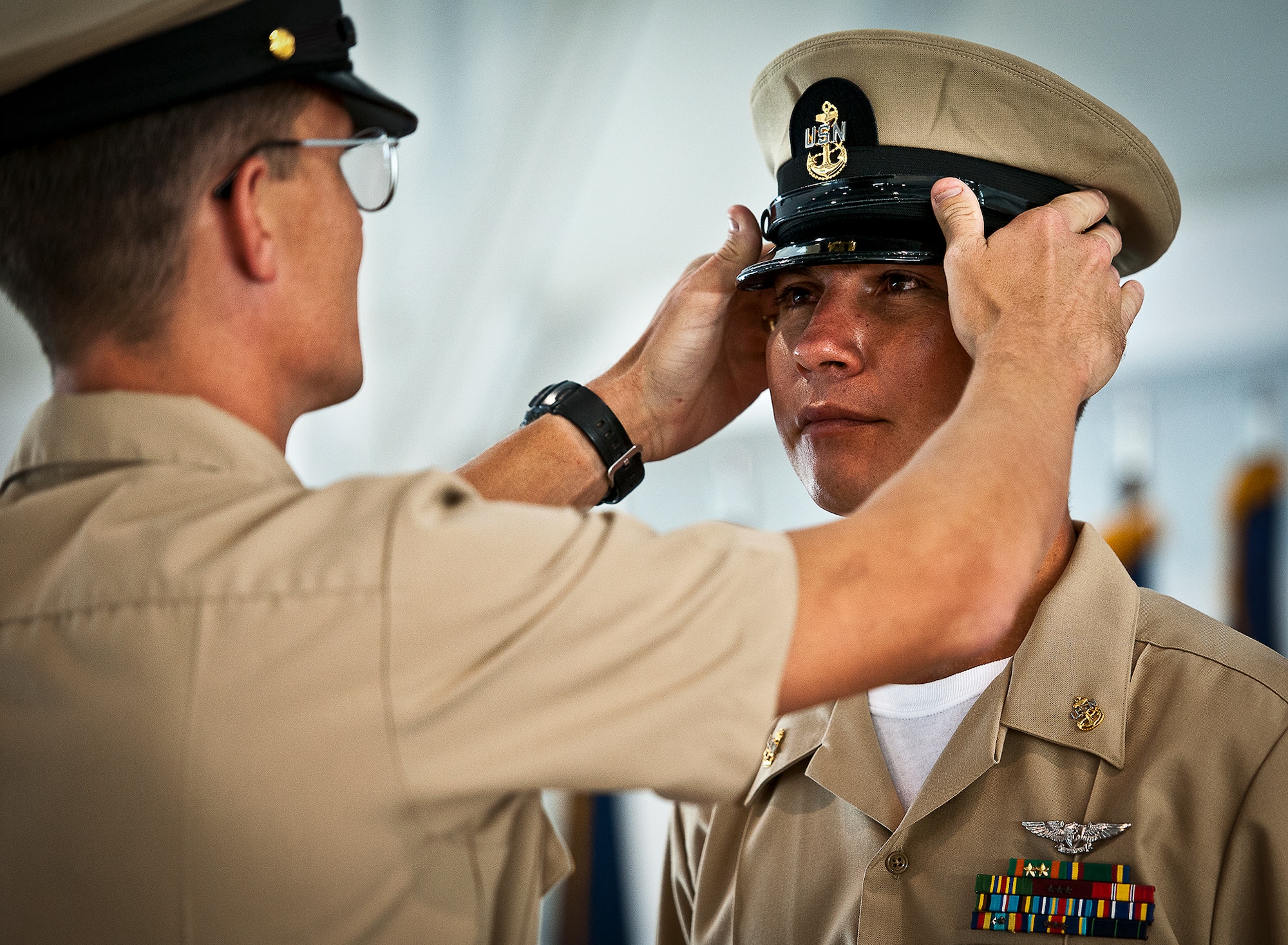Newly-pinned Chief Petty Officer Roberto Sanchez has his new combination cap set for him by his sponsor during his pinning ceremony held by the Navy's F-35 Lightning II squadron, VFA-101, Sept. 14 at Eglin Air Force Base, Fla.  The ceremony formally marks the transition from E-6 to chief.  A new chief’s sponsor guides him through a six-week induction process. There were four Sailors who pinned on the new rank. A Marine and a Soldier were also pinned as honorary chiefs. (U.S. Air Force photo/Samuel King Jr.)