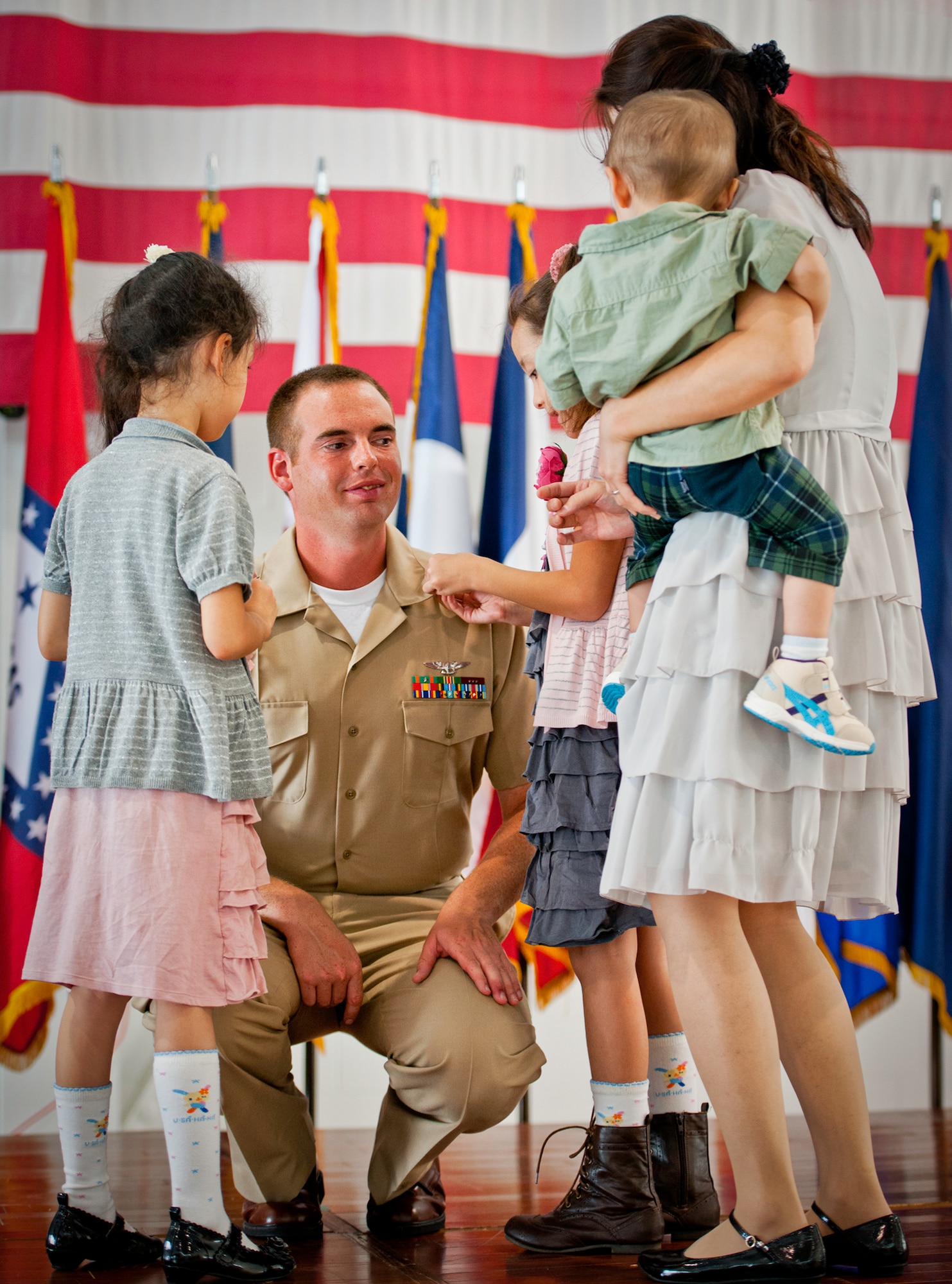 Newly-promoted Chief Petty Officer John Adair has his anchors pinned on by his daughters during his pinning ceremony held by the Navy's F-35 Lightning II squadron, VFA-101, Sept. 14 at Eglin Air Force Base, Fla.  The ceremony formally marks the transition from E-6 to chief. There were four Sailors who pinned on the new rank. A Marine and a Soldier were also pinned as honorary chiefs.  (U.S. Air Force photo/Samuel King Jr.)