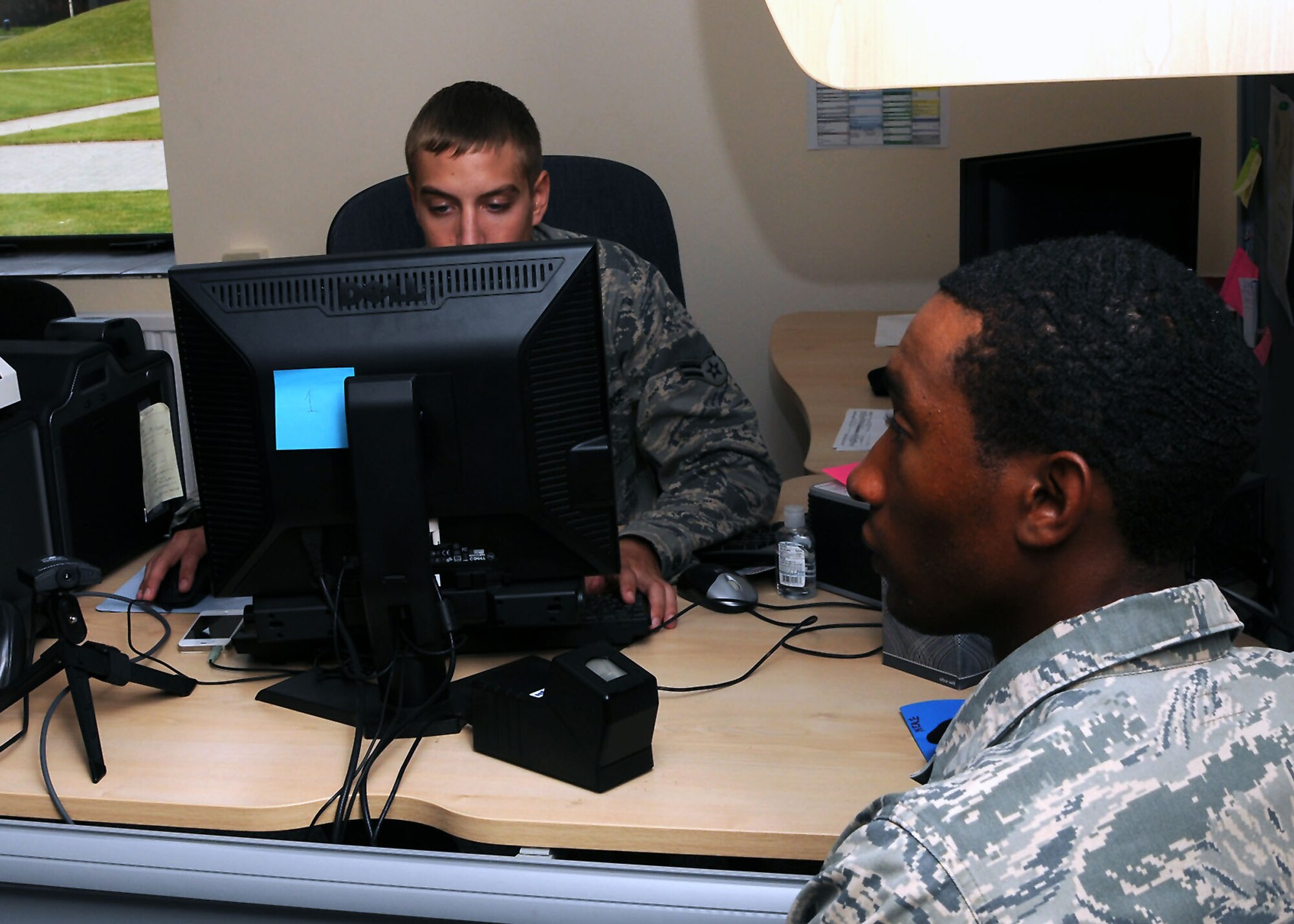 RAF Mildenhall, England – Left, Airman 1st Class Tyler Harryman, 100th Security Forces Squadron, takes a picture of Airman 1st Class Daquan Neale, 100th SFS, at the pass and registration center on RAF Mildenhall, England Sept. 14, 2012. Neale was having his picture taken as part of his in-processing the Installation Access Control System at the base. The IACS is used as an extra security measure. (U.S. Air Force photo/Airman 1st Class Kelsey Waters) 

