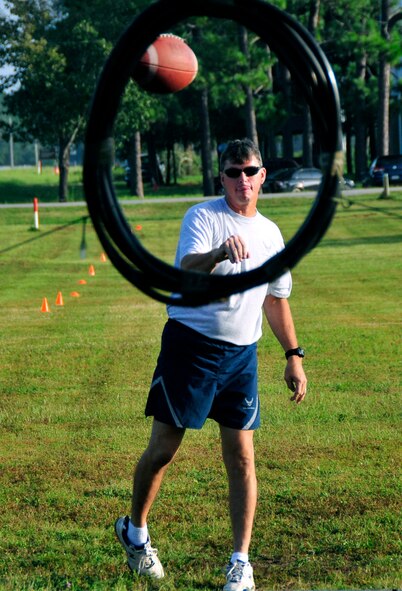 Master Sgt. Lonney Melton of the 919th Maintenance Squadron makes a throw in the Football Hoop Throw Challenge during the 919th Maintenance Group Olympics Sept. 8, 2012 at Duke Field, Fla.  The event featured 12 different team events aimed at boosting unit morale and team building. (U.S. Air Force photo/Tech. Sgt. Jasmin Taylor)