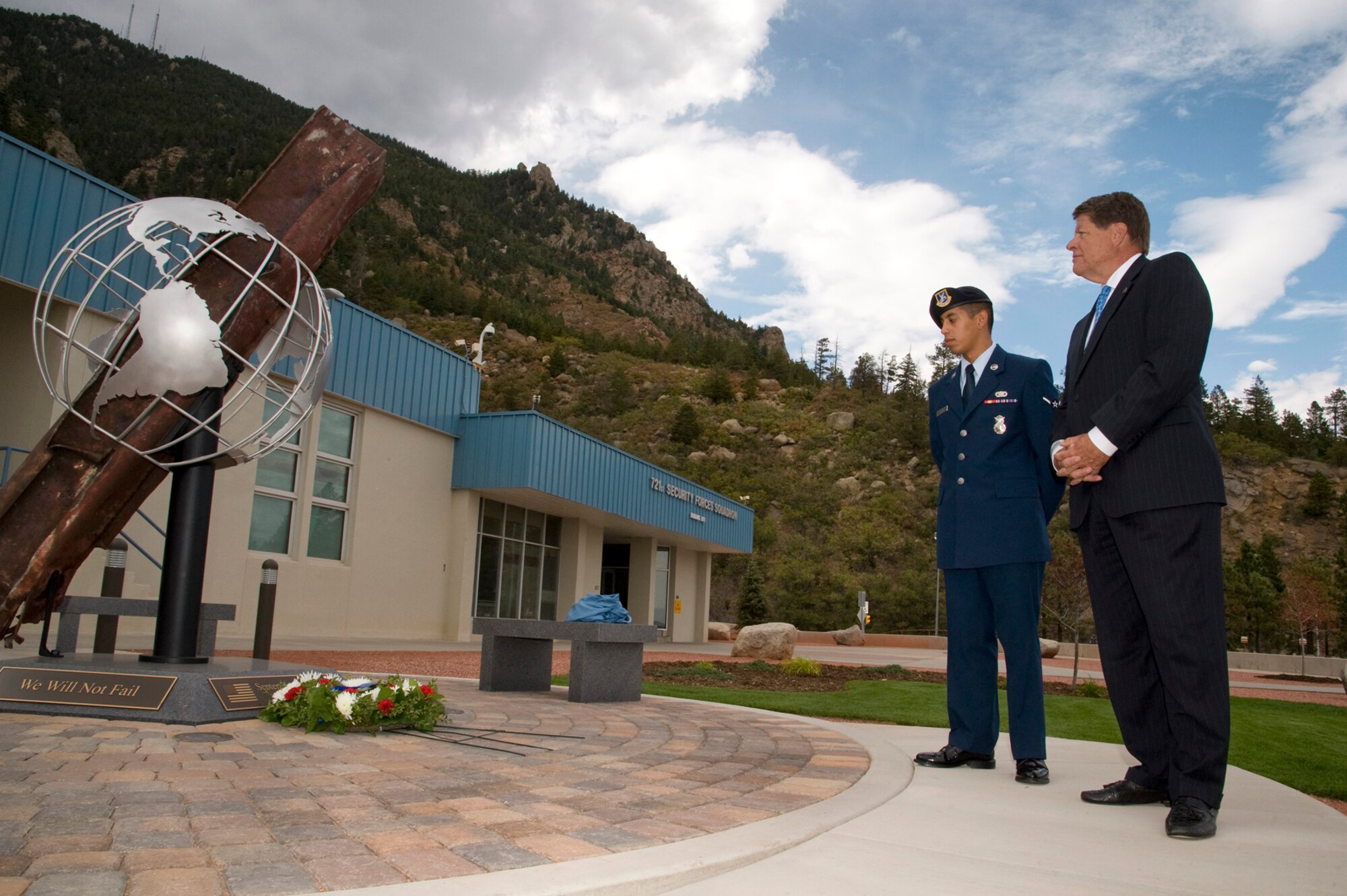 Don Addy (right), Colorado 30 Group chairman and Colorado National Defense Support Council chairman, and Airman Christian Mejia, 721st Security Forces Squadron, reflect upon the 9/11 artifact and memorial at Cheyenne Mountain Air Force Station Sept. 11. The artifact contains a steal beam from the World Trade Center. Addy secured this artifact, along with seven others for the local area, during his time as president of the National Homeland Defense Foundation. The artifact was dedicated last year at the 10th anniversary ceremony. (U.S. Air Force photo/Craig Denton)