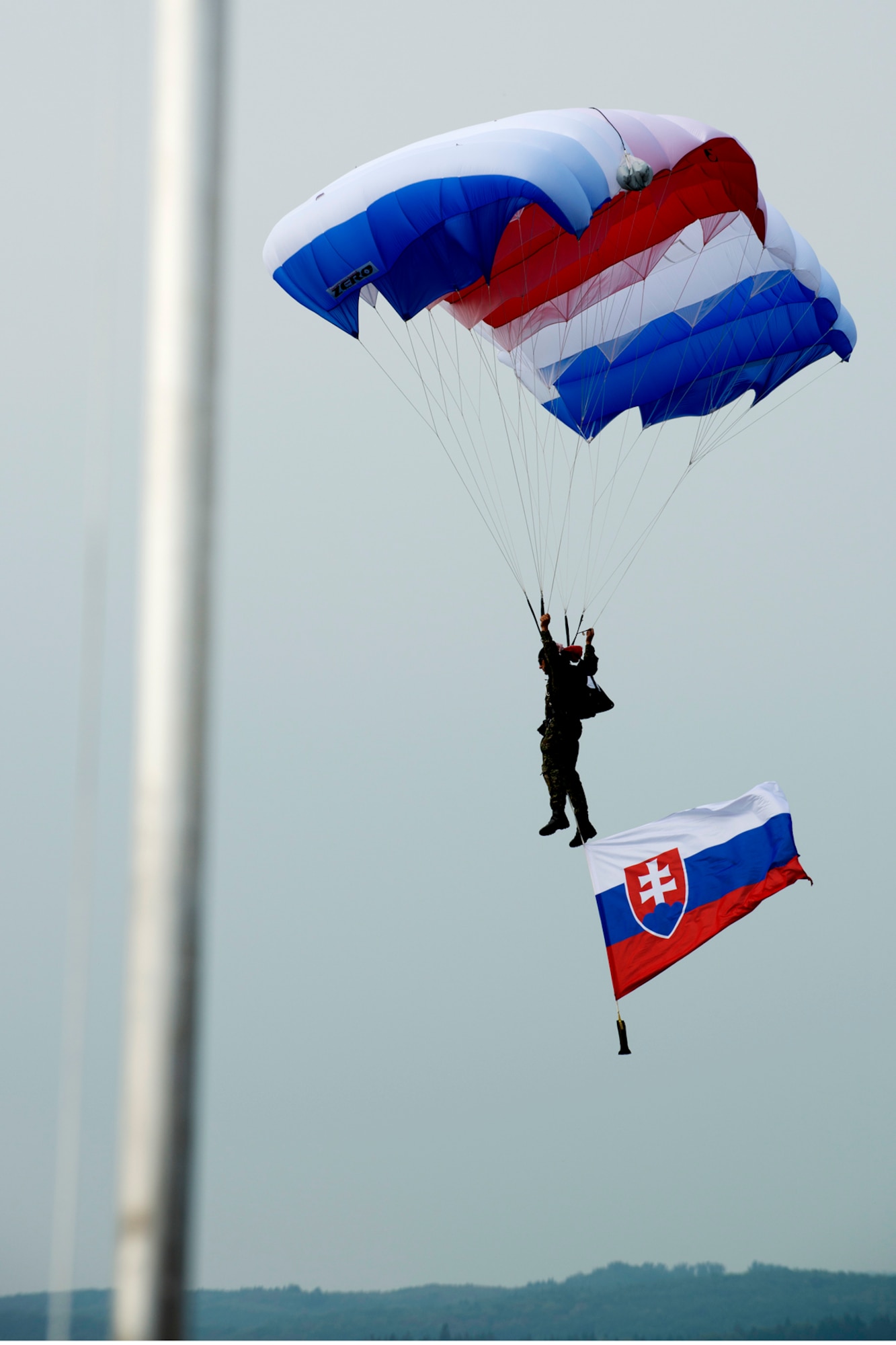 A parachutist flying the flag of the Slovak Republic, is seconds from landing during the opening ceremonies for the Slovak International Air Fest, Sept. 2, 2012, Sliac, Slovakia. An estimated 115,000 people attended the two-day air show, which hosts aerial demonstrations and displays from countries throughout Europe and Asia. (U.S. Air Force photo by Master Sgt. Greg Steele/Released)