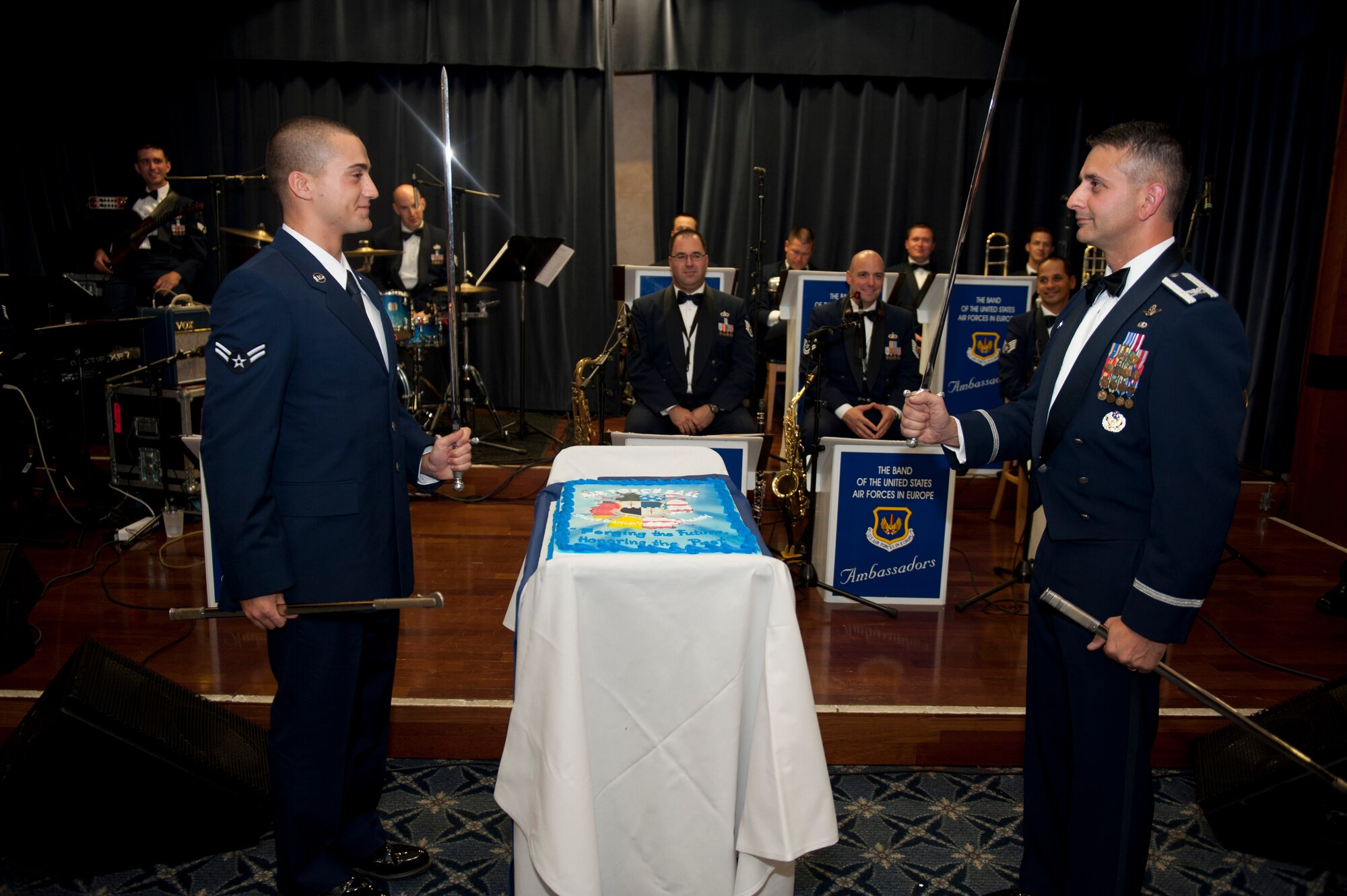 SPANGDAHLEM AIR BASE, Germany – Col. David Julazadeh, 52nd Fighter Wing commander, and Airman 1st Class Omar Santana, 52nd Logistics Readiness Squadron fuels distribution operator, prepare to cut a cake using sabers at Spangdahlem’s Air Force ball inside the Eifel Club Ballroom here Sept. 15.  The event was in celebration of the Air Force’s 65 years as an independent service with a theme of forging the future and honoring the past. (U.S. Air Force photo by Airman 1st Class Gustavo Castillo/Released)
