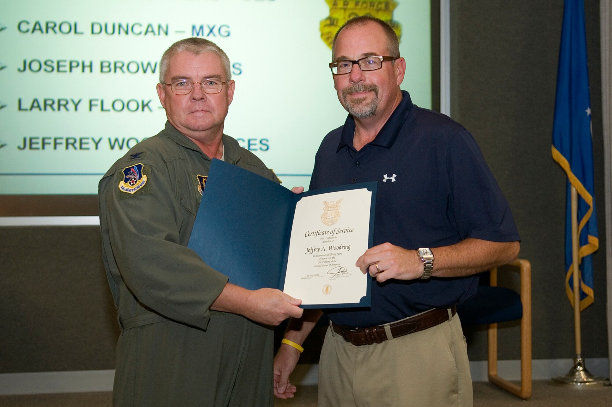 GRISSOM AIR RESERVE BASE, Ind. -- Jeffrey Woodring, 434th Mission Support Group environmental flight chief, receives a 30-year government service recognition award from Col. Don Buckley, 434th Air Refueling Wing commander, during a civilian commander's call here Sept. 13. Wooding overseas environmental programs concerning environmental quality, installation restoration, planning and environmental compliance. (U.S. Air Force photo/Staff Sgt. Ben Mota)