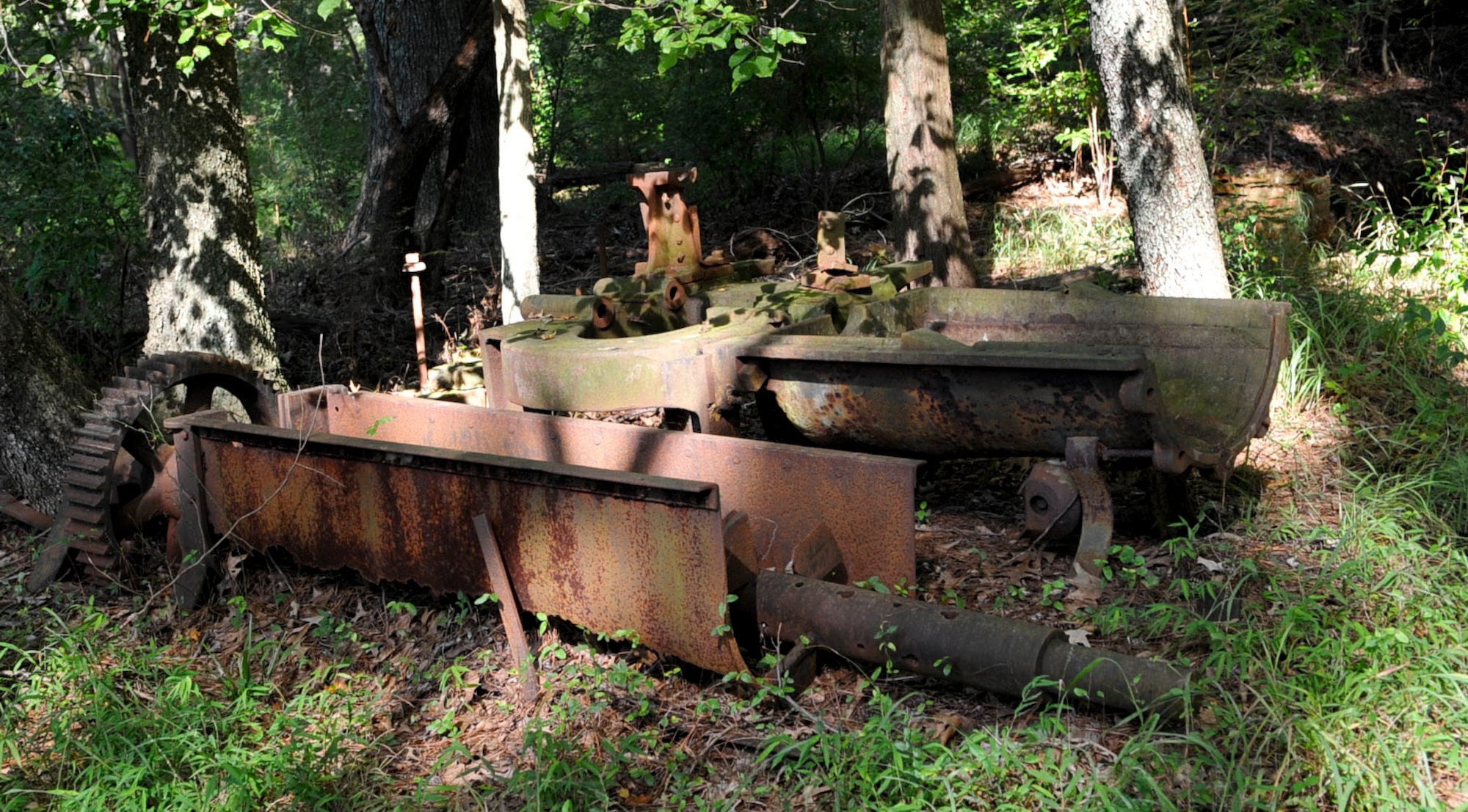 A rusted pug mill (left) and disintegrator from the Davis and Kimpton Brickyard rest in the woods at Training Area #23 on Fort Eustis, Va., Sept. 14, 2012. The disintegrator was used to grind clay and elements to a uniform consistency, while the pug mill shaped and cut the materials into bricks, before being fired in a nearby kiln. (U.S. Air Force photo by Staff Sgt. Wesley Farnsworth / Released)