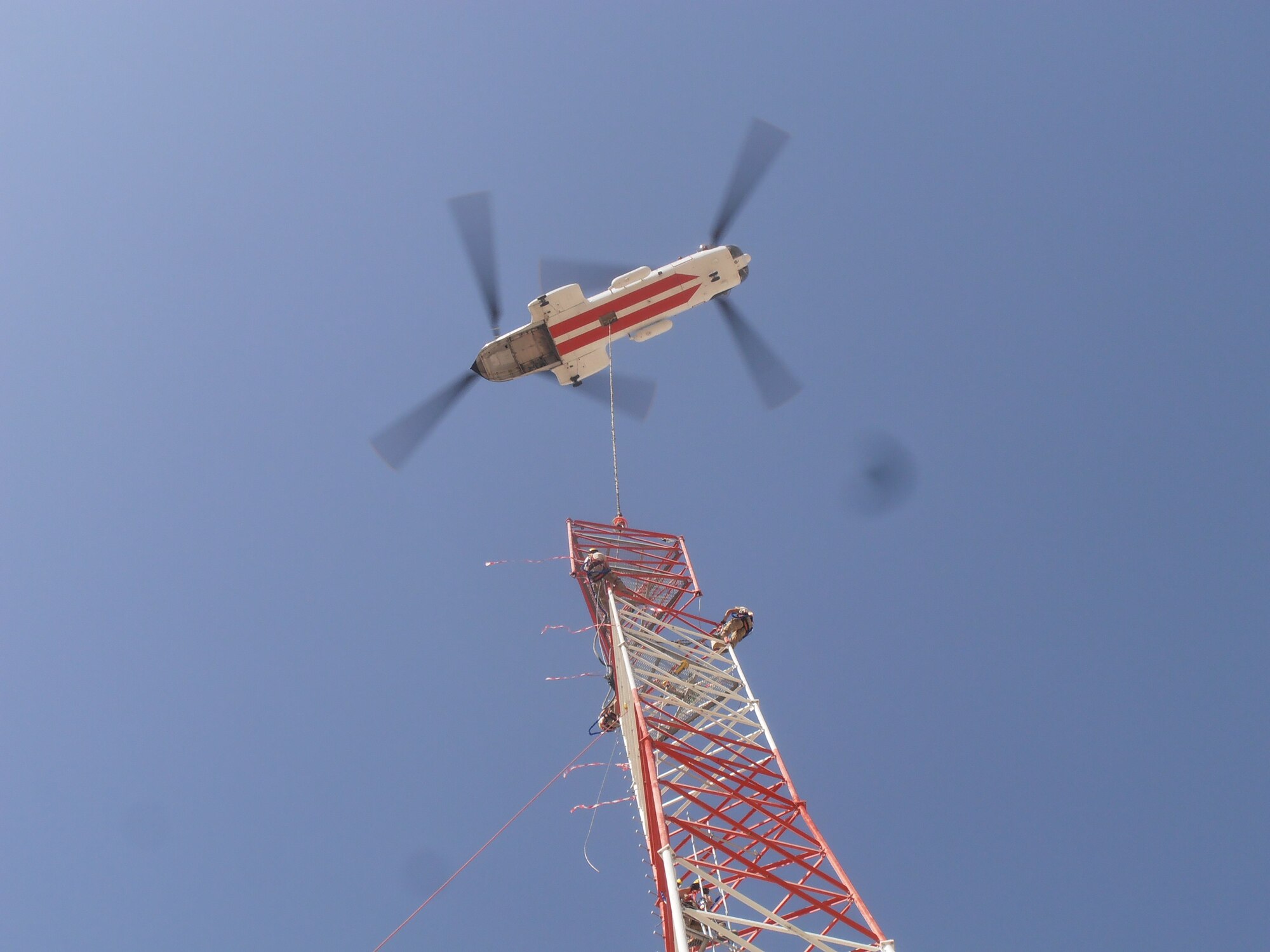 Three Airmen from the Air National Guard Engineering and Installation Team a top of a 150 foot tower to assemble the final piece. A specialized team from several Air National Guard Engineering Installation Squadrons deployed to Bagram Airfield, Afghanistan, combined their efforts to built and setup the 170-foot communications tower, greatly increasing radio communication range. (U.S. Air Force photo/1Lt. Bruce Champion)