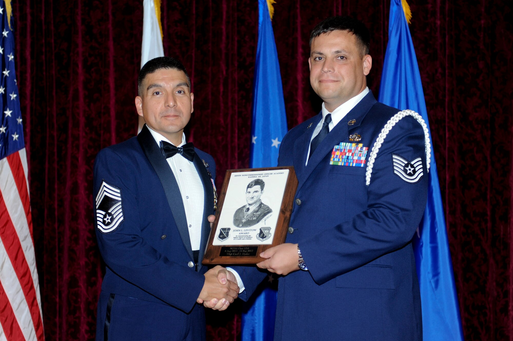 U.S. Air Force Chief Master Sgt. Richard Vargas, 18th Communications Squadron chief, presents the John L. Levitow award to Tech. Sgt. Cecil J. Hyder, 644th Combat Communication Squadron, Andersen AFB, at the NCO Academy graduation on Kadena Air Base, Japan, Sept. 14, 2012. The distinguished graduate award, sponsored by the Kadena Chiefs group, is named in memory of Medal of Honor recipient, Airman 1st Class John L. Levitow. The award is presented to the most outstanding member of class 12-6 and denotes superior achievement as both a leader and a scholar. (U.S. Air Force photo/Airman 1st Class Hailey R. Davis)