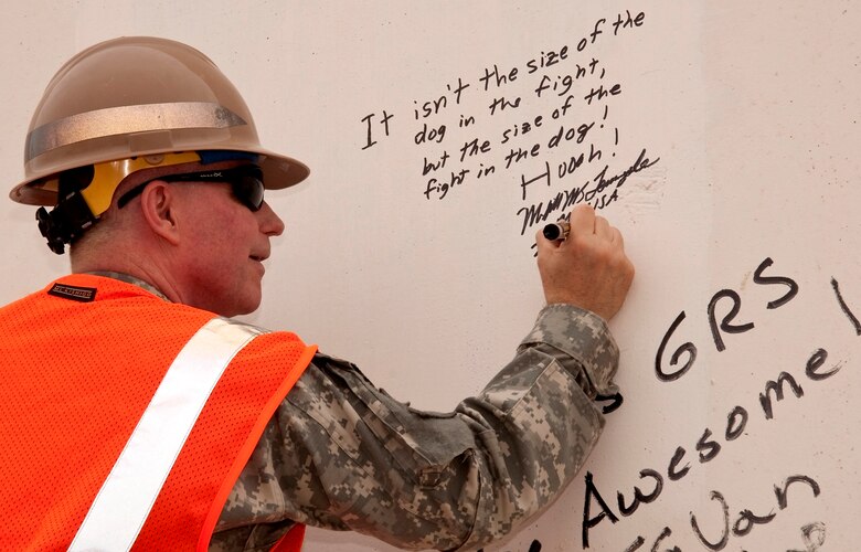 Maj. Gen. Merdith W.B. “Bo” Temple, former deputy commander of the U.S. Army Corps of Engineers, signs a protective wall with a personal motto at the Corps’ Gulf Region South compound near Basra, Iraq, in October 2009.  Temple retired from the U.S. Army Aug. 31, 2012.  (U.S. Army Corps of Engineers Photo)