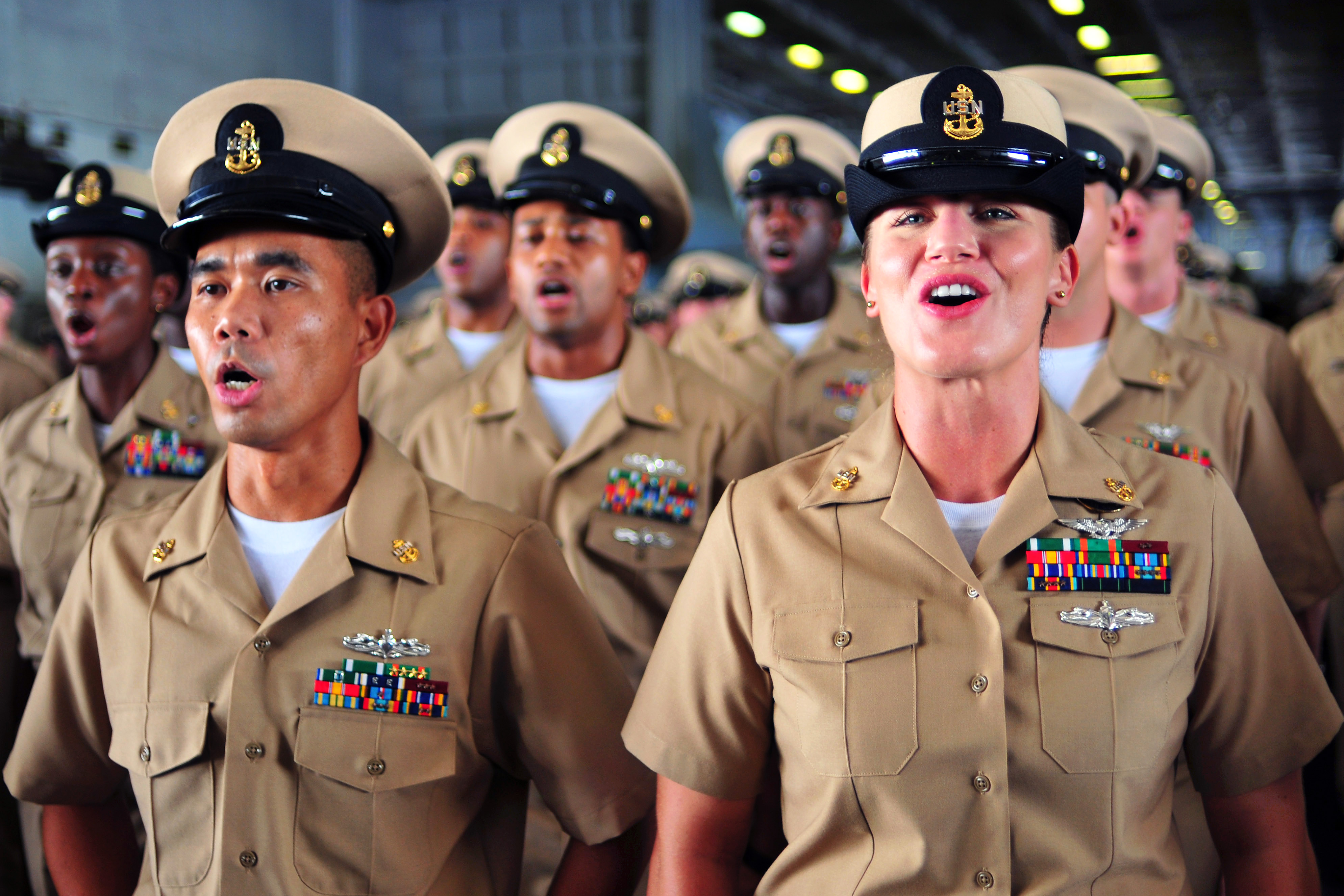 Newly frocked U.S. Navy chief petty officers sing "Anchors Aweigh