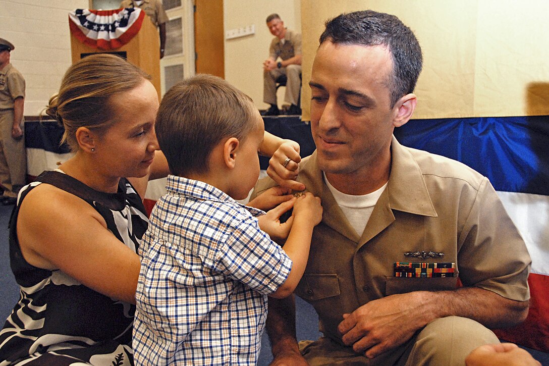 Newly frocked Navy Chief Petty Officer Manuel Soares receives his collar devices from his son and wife during a pinning ceremony at Naval Station Norfolk, Va., Sept. 14, 2012. Soares is a machinist's mate.