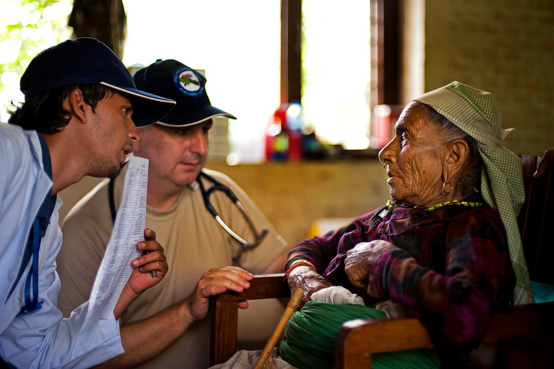 A Nepalese doctor, left, and U.S. Air Force Lt. Col. Michael Wood, center, listen as a patient describes her symptoms during Pacific Angel 12-4 in Pokhara, Nepal, Sept. 11, 2012. Wood is assigned to the 15th Medical Group.