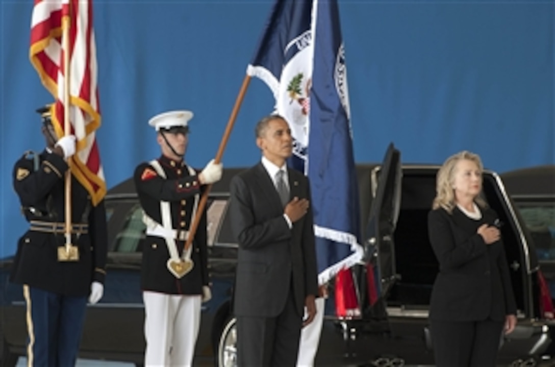 President Barack Obama and Secretary of State Hillary Clinton pause as the national anthem is played during the dignified transfer ceremony for the U.S. Ambassador to Libya J. Christopher Stevens, Foreign Service officer Sean Smith, and security officers Tyrone S. Woods and Glen A. Doherty at Joint Base Andrews, Md., on Sept. 14, 2012.  