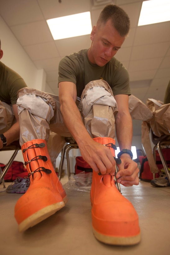 Lance Cpl. Dylan Tinsley, Jonesboro, Ark., native and 26th Marine Expeditionary Unit chemical, biological, radiological and nuclear defense specialist, dawns his personal protective equipment at Fort Pickett, Va., Sept. 14, 2012. The CBRN Marines cross trained with the Army National Guard CBRN enhanced reaction force package and the Air Force to get a better understanding on how different branches conduct decontamination. This training is part of the 26th MEU's pre-deployment training program. The 26th MEU is slated to deploy in 2013.