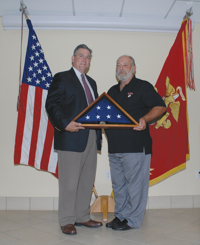 Mike Williamson, left, director, Logistics Services Management Center, Marine Corps Logistics Command, presents Richard “Rich” Zupko’s logistics management specialist, LSMC, Command, Control, Communications, Computers and Intelligence Systems Division, MCLC, with an American flag during his retirement ceremony, Aug 21.
