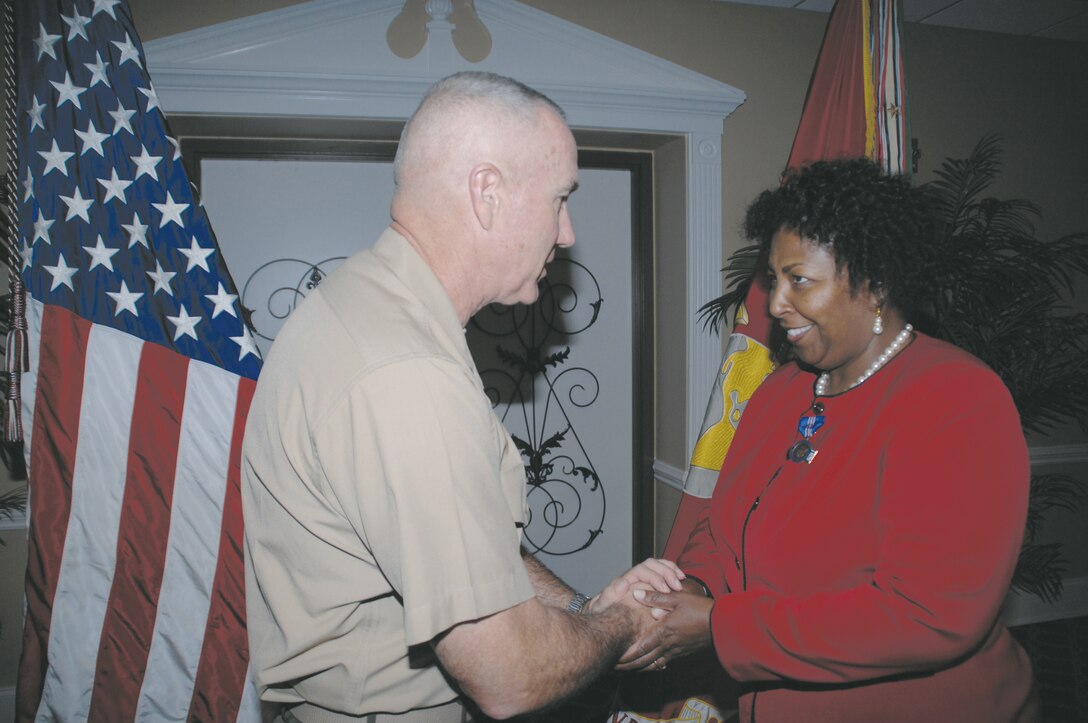 Maj. Gen. Charles Hudson, commanding general, Marine Corps Logistics Command, praises Pamela Bryant on her 35 years of     government service. Bryant retired Aug. 24 during a ceremony at the Grand Ballroom.