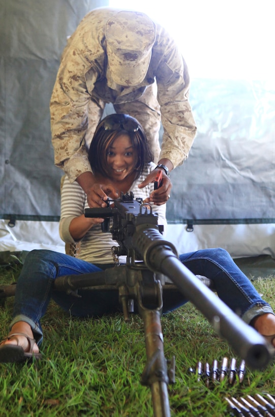 Cpl. Darius Jenkins, a motor vehicle operator with Combat Logistics Battalion 6, 2nd Marine Logistics Group, demonstrates how to operate the .50-caliber machine gun to his wife, Erica Jenkins, during the unit’s Jane Wayne Day activities aboard Camp Lejeune, N.C., Sept. 12, 2012. The event’s activities helped the spouses and families of the Marines gain a greater understanding of the daily responsibilities of their servicemembers while giving them hands-on experience with the unit’s equipment.