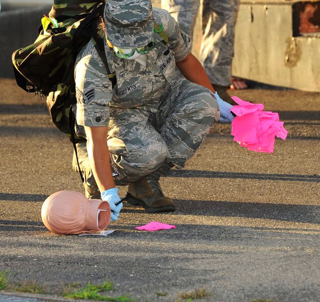 U.S. Air Force Senior Airman Gretchen Sarmiento, 35th Force Support Squadron search and recovery member, marks the location of a simulated dismembered head during an emergency management exercise at Misawa Air Base, Japan, Sept. 17, 2012. By marking the location of evidence, the scene can be reconstructed at a later date. (U.S. Air Force photo by Airman 1st Class Kenna Jackson/Released)