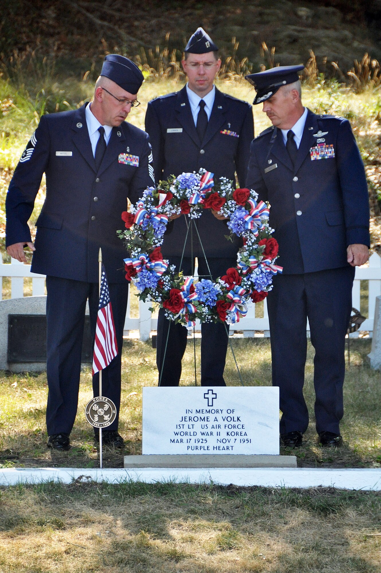 Chief Master Sgt. Jeffrey Neitzel, Capt. John O'Brien and Col. Gary Ebben place a wreath at the memorial marker of 1st Lt. Jerome Volk during a July 11 memorial service at Volk Field. The service rendered final respects and honors to the base's namesake, the first Wisconsin Air National Guard pilot to die in the line of duty during the Korean conflict. Volk was shot down during a combat sortie against communist forces Nov. 7, 1951, and his remains have never been recovered. In 1957 the Wisconsin legislature renamed the portion of Camp Williams used by the Wisconsin Air National Guard as Volk Field. Don Volk, 1st Lt. Volk's younger brother and next of kin, and dozens of other relatives attended the ceremony, which included full military honors such as a color guard, rifle squad, and a "missing-man formation" F-16 fly-over. Wisconsin National Guard photo by 1st Sgt. Vaughn R. Larson 