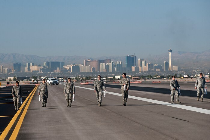 Airmen walk the runway on the Nellis Air Force Base airfield during a foreign object debris walk Sept. 14, 2012, at Nellis AFB, Nev. Due to recent construction on the airfield a FOD walk was required to minimize the amount of debris and help ensure the safety of Airmen and aircraft. (U.S. Air Force photo by Staff Sgt. Christopher Hubenthal)