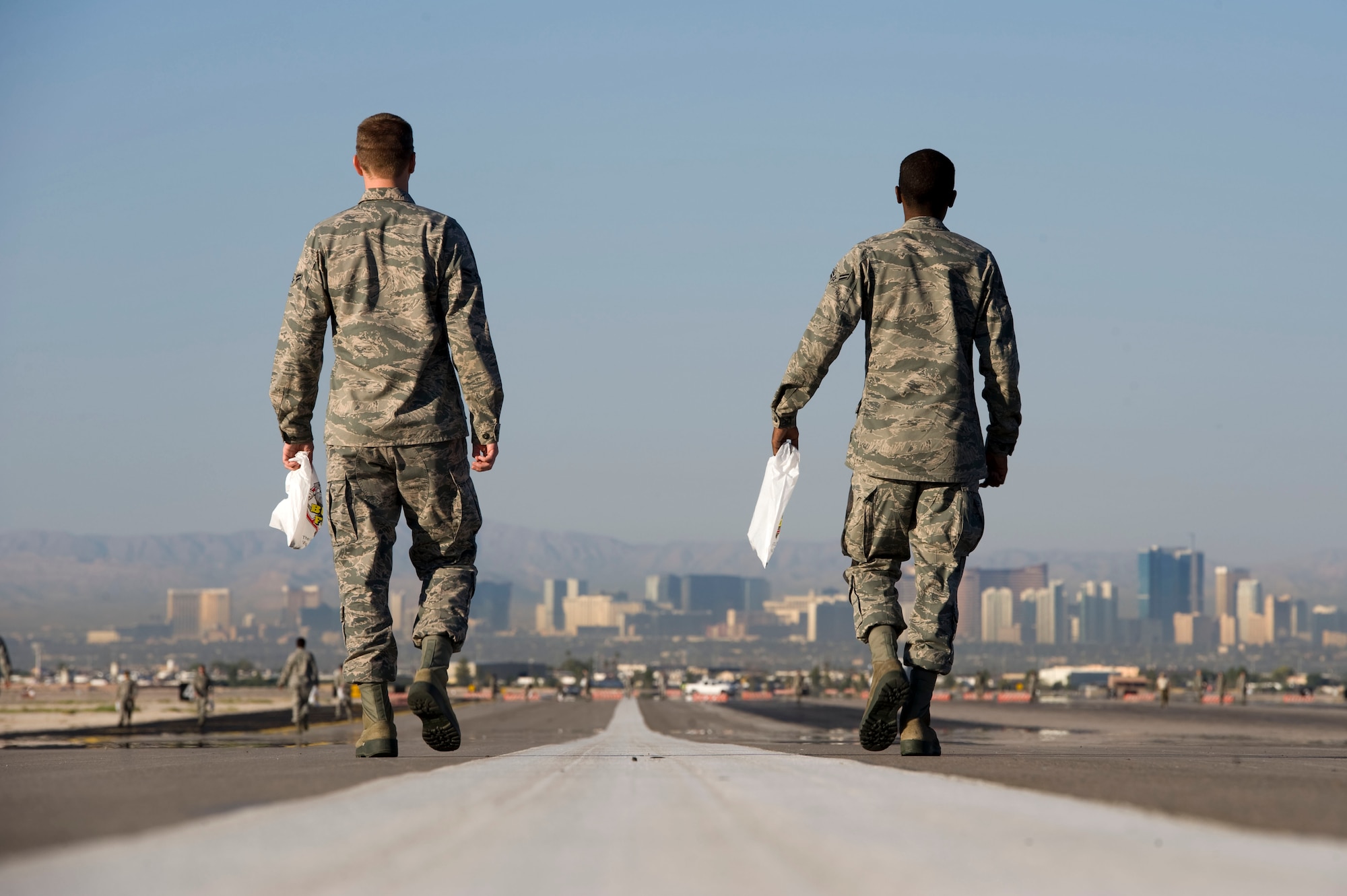 Airman 1st Class Clifton Ford and Airman 1st Class Derek Mobley, 57th Operations Support Squadron air traffic controllers, walk down the runway looking for trash during a Foreign Object Debris walk Sept. 14, 2012, at Nellis Air Force Base, Nev. Seventy-two Airmen and two sweeper trucks participated in the FOD walk which is conducted to ensure the safety of aircraft and Airmen. (U.S. Air Force photo by Airman 1st Class Christopher Tam)

