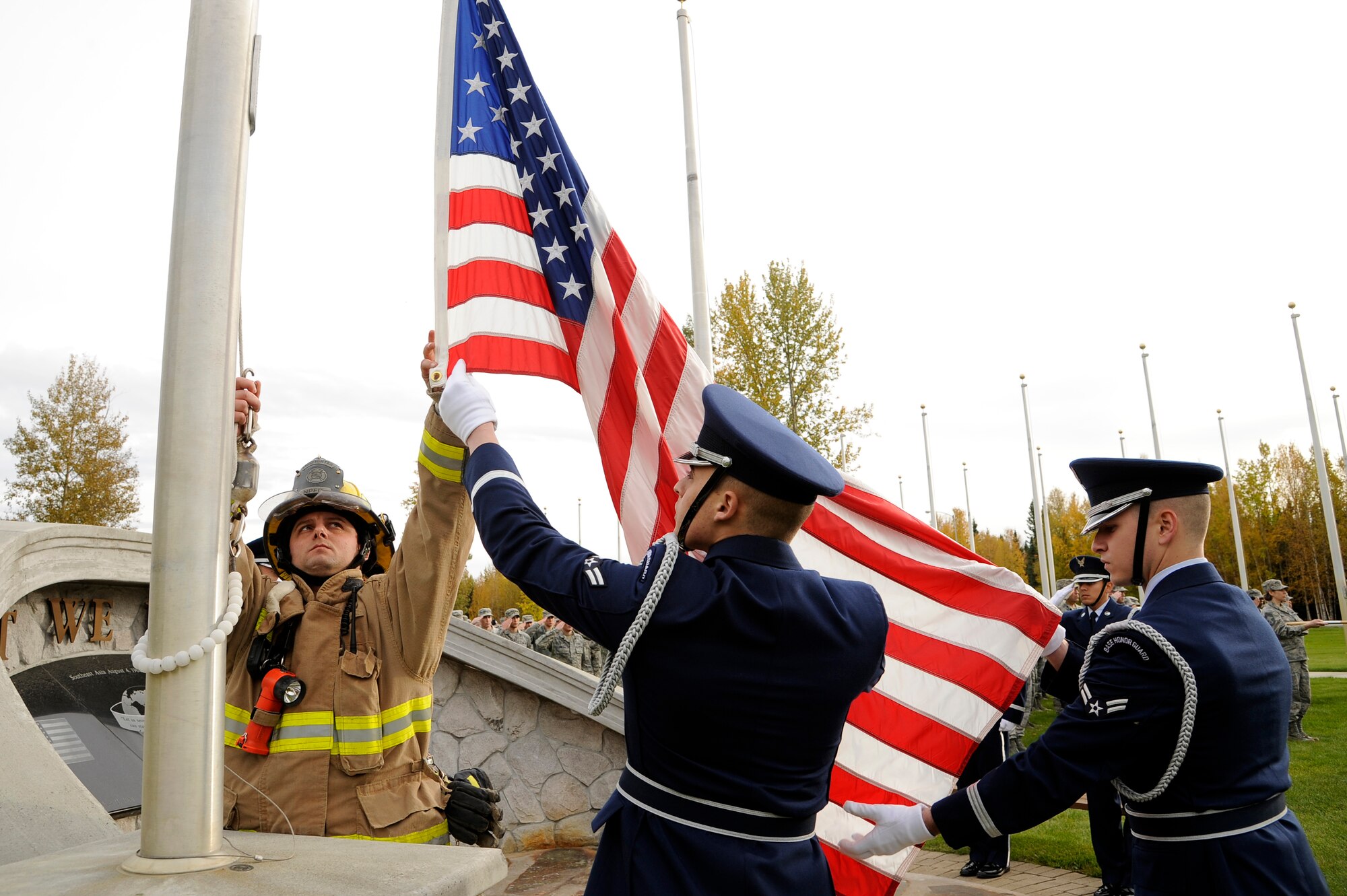 Eielson Air Force Base honor guard members and Jesse Stern, a North Pole Fire Department firefighter, take down the American flag during a prisoner of war/missing in action ceremony Sept. 14, 2012, Eielson AFB, Alaska. The POW/MIA retreat ceremony commemorates the men and women of the armed forces who have given immense sacrifices while in military service. (U.S. Air Force photo/Staff Sgt. Jim Araos)