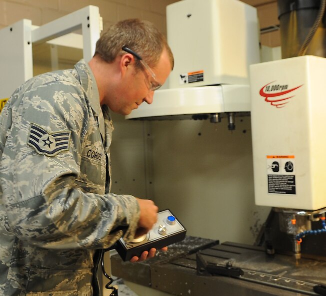 Staff Sgt. David Cordes, 2nd Maintenance Squadron aircraft metals technology craftsman, uses a hand jog to manually move the quill and table on a computer numerical control mill on Barksdale Air Force Base, La., Sept. 18. Although usually automated, the mill can be controlled by hand to create aircraft brackets, test fixtures and anything else need to support the aircraft. (U.S. Air Force photo/Senior Airman Kristin High)(RELEASED)