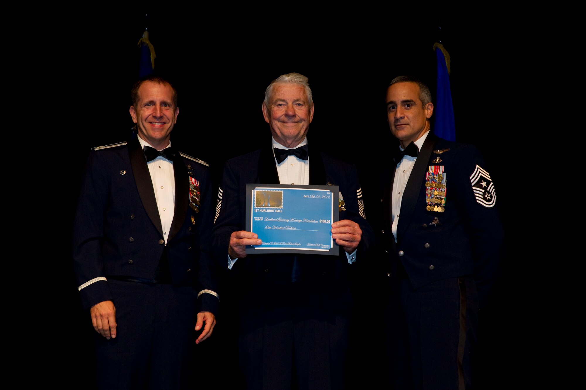 Col. Jim Slife, commander of 1st Special Operations Wing, left, and Chief Master Sgt. Ramon Colon-Lopez, command chief of 1st SOW, right, present a donation certificate to Chief Master Sergeant of the Air Force Robert Gaylor, the fifth chief to serve as the Air Force's top enlisted Airman, center, at the inaugural Hurlburt Ball at the Emerald Coast Conference Center on Okaloosa Island, Fla., Sept. 14, 2012. Gaylor was the guest speaker for the ceremony, themed "Reflecting Our Past, Sustaining Our Future." (U.S. Air Force photo / Tech. Sgt. Vanessa Valentine)