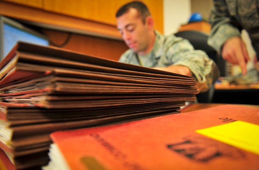 U.S. Air Force Senior Airman Sheldon Murphy, 23d Contracting Squadron contracting specialist, works on paperwork as a stack of folders sits on his desk at Moody Air Force Base, Ga., Sept. 11, 2012. Contracting specialists purchase equipment for units by reviewing requirements, soliciting for better prices and conducting market research to get the most out of tax-payer dollars. (U.S. Air Force photo by Airman 1st Class Jarrod Grammel/Released)
