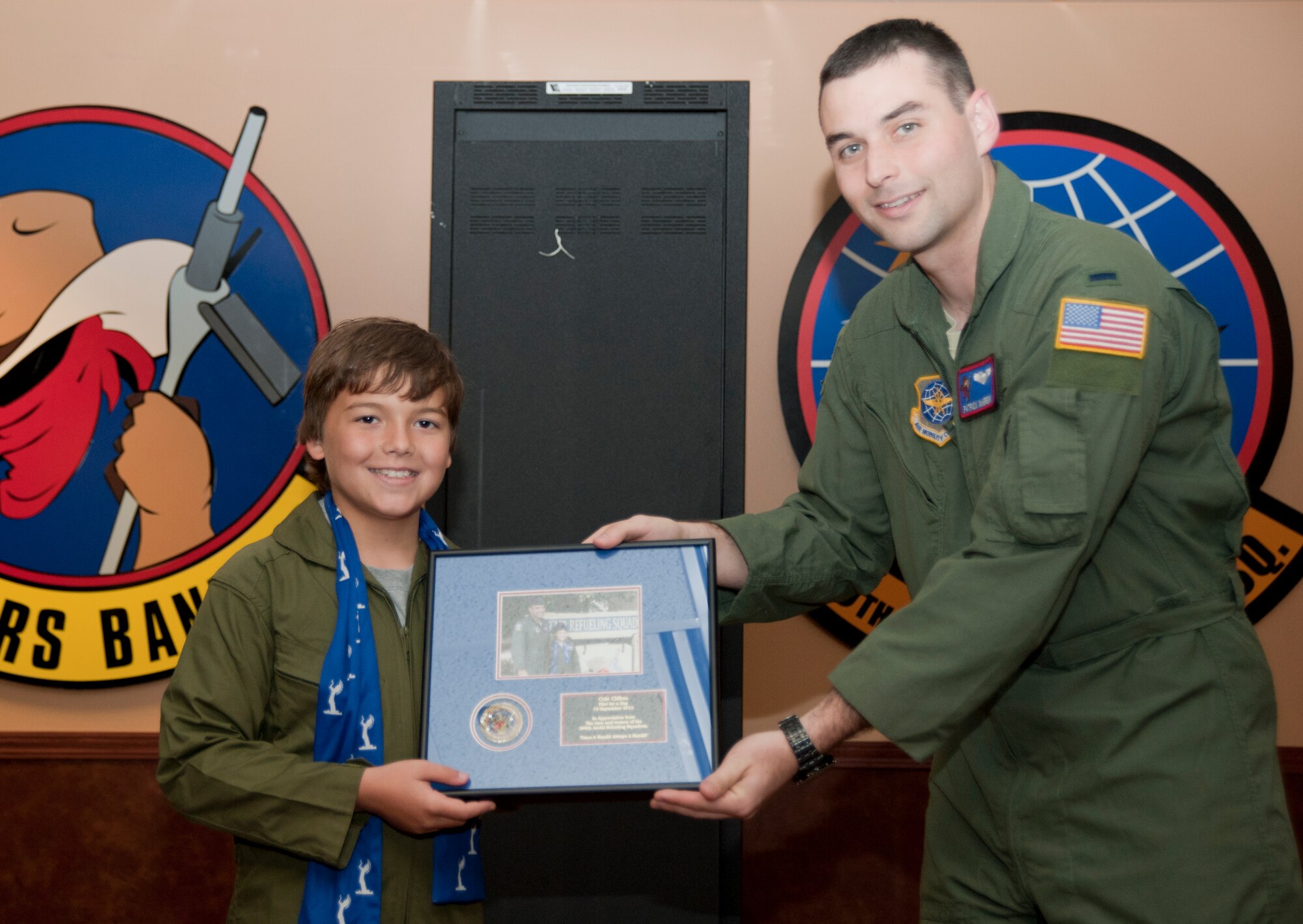 Cole Clifton, 11, accepts a plaque recognizing him as a Pilot for a Day from 1st Lt. Patrick McGrew, 349th Air Refueling Squadron training flight officer, Sept. 13, 2012, McConnell air Force Base, Kan. The Pilot for a Day program gives children with severe illnesses a chance to visit various units on base and experience what it is like to be an Airman. (U.S. Air Force photo/Airman 1st Class Victor J. Caputo)