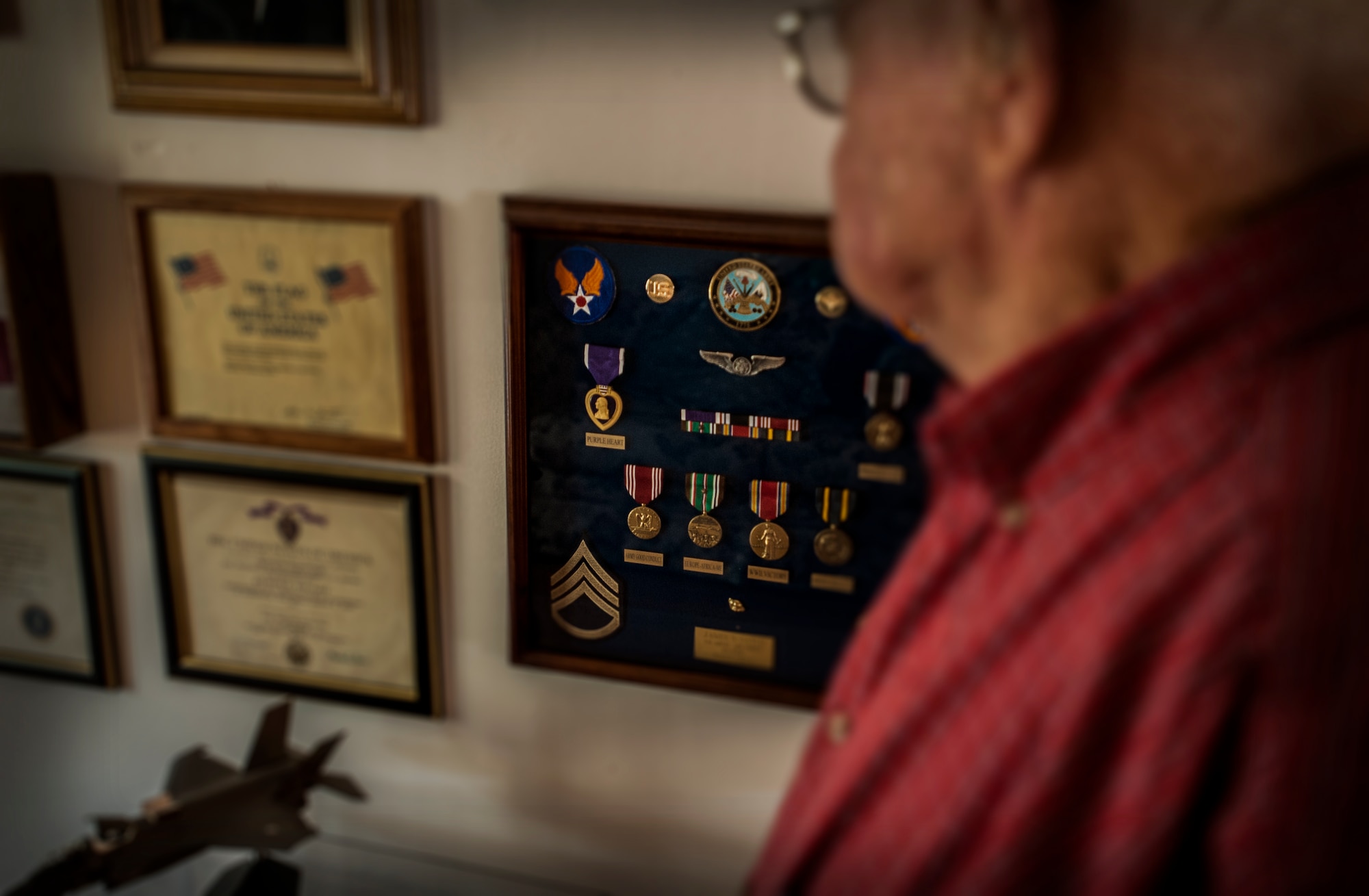 Jim Gatch, 89-year-old Army Air Corps veteran and World War II Prisoner-of-War, reflects on his POW experience by looking at his military decorations, including the Purple Heart, for a photograph Sept. 10, 2012, at his home in Summerville, S.C. On May 12, 1944, while assigned to the 379th Bomb Group, Gatch was a base gunner on a B-17 aircraft that was shot down by the Germans. He was captured y the enemy and remained a POW for 358 days. The Purple Heart is a United States military decoration awarded in the name of the President to servicemembers wounded or killed while serving on or after April 5, 1917. On Sept. 21, Gatch will be in attendance with other surviving Lowcountry POWs in observance of the National POW/MIA Recognition Day. (U.S. Air Force Photo / Airman 1st Class Tom Brading)