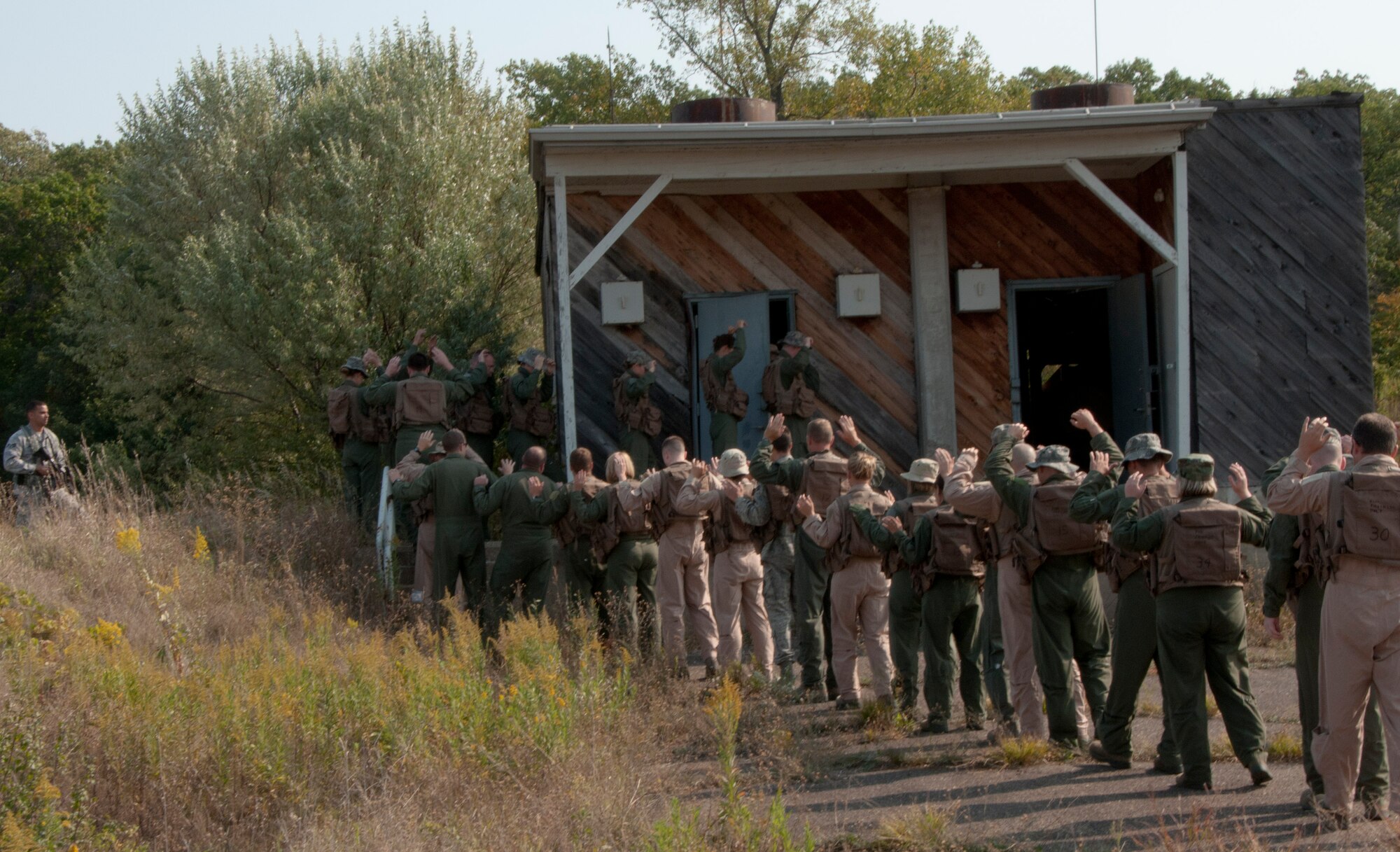 Members of the 133rd Airlift Wing are taking part in survival, evasion, resistance, and escape (SERE) training at the Army Training Site Arden Hills, Minnesota Sept. 16, 2012. Airmen are herded into mock holding cells by members of the 133rd Security Forces Squadron role playing the part of enemy captors this training allows Airmen to practice their SERE skills learned outside the classroom. U.S. Air Force photo by Tech. Sgt. Erik Gudmundson/released
