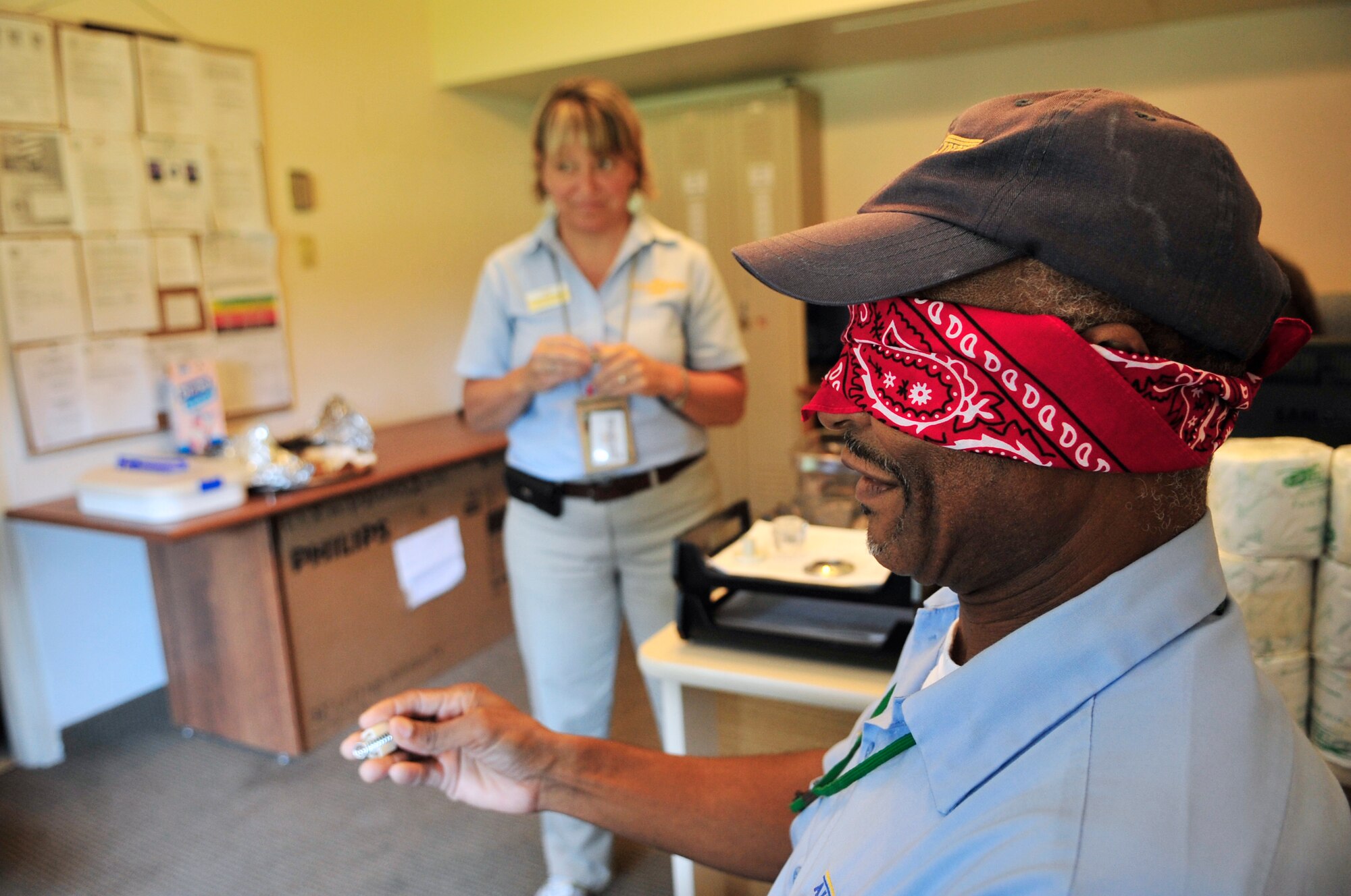 Earl Drakeford, Carolina Pines Inn custodial worker, sits blind-folded as he guesses the object at Shaw Air Force Base, S.C., Sept. 10, 2012. This contest was in celebration of the international housekeeping week, a week to show appreciation to the staff.(U.S. Air Force photo by Airman Nicole Sikorski/Released)