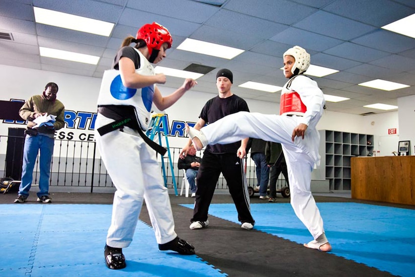 Cherrelle e'Lan, portraying Lynnette Love, 1988 taekwondo Heavy Weight Gold Medalist, spars with Courtney Schwartz who plays Arlene Limas, 1988 taekwondo Welter Weight Gold Medalist, as Freddy Bouciengues, actor/fight choreographer, portraying Coach Simms referees the bout in the short presentation of “Seoul, U.S.A.” (Courtesy photo/Tabrina Hobson)