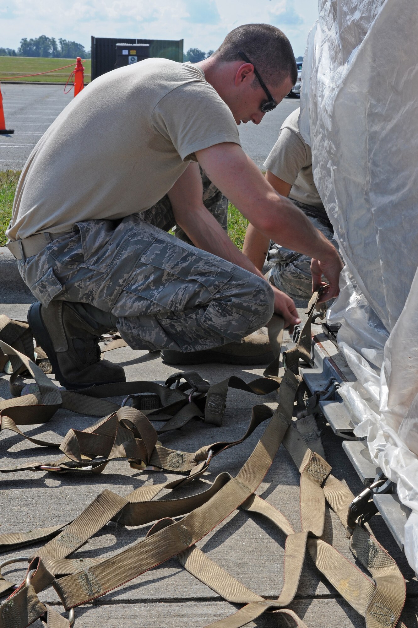 U.S. Air Force Senior Airman Daniel Worthen, 4th Force Support Squadron unit deployment manager, locks a netting into place to cover cargo during Phase I of Operational Readiness Exercise Coronet Warrior 12-04 at Seymour Johnson Air Force Base, N.C., Sept. 17, 2012. The 4th Fighter Wing will conduct multiple OREs to prepare for an upcoming operational readiness inspection in the spring of 2013. (U.S. Air Force photo/Airman 1st Class John Nieves Camacho/Released)