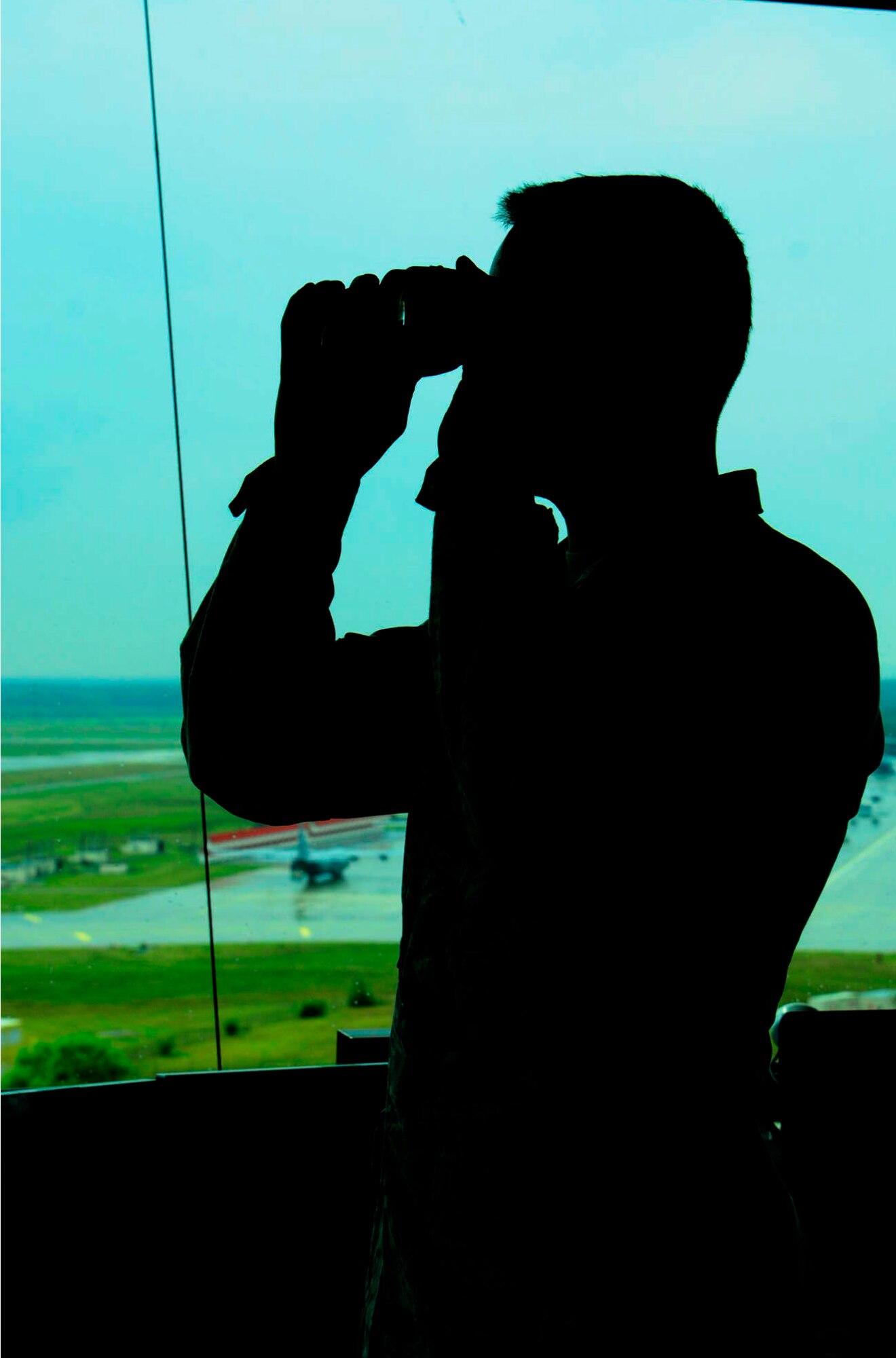 Senior Airman Kyle Gibson, 86th Operations Support Squadron air traffic controller, looks through a pair of binoculars in the air traffic control tower, Ramstein Air Base, Germany Sept. 11, 2012 . Air traffic controllers provide safe and expeditionary air traffic flow by giving pilots a clear and precise picture of where they are and what is in the air space near them. (U.S. Air Force photo/Airman 1st Class Hailey Haux)