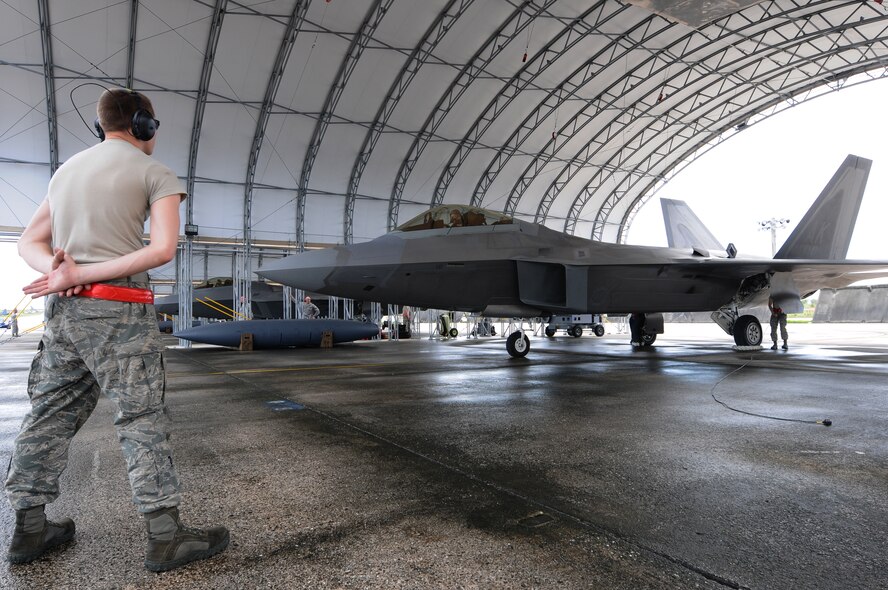 ANDERSEN AIR FORCE BASE, Guam – Airman 1st Class Jordan Morin, 90th Expeditionary Aircraft Maintenance Unit crew chief stands ready to marshal out an F-22, Sept. 17. Airman Morin is a crew chief on an F-22 Raptor from the 90th Fighter Squadron, 3rd Wing, Joint Base Elmendorf-Richardson. (U.S. Air Force photo by Senior Airman Carlin Leslie/Released)