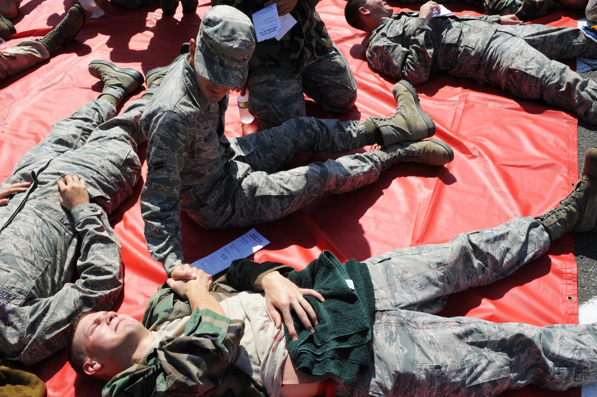 Simulated victims comfort each other while awaiting medical care after a simulated explosion during an Emergency Management Exercise at Misawa Air Base, Japan, Sept. 17, 2012. Firefighters and uninjured personnel carried the victims to a safe distance to prevent further injuries in the case of a secondary blast. The conducted exercise was part of the 35th Fighter Wing's Combined Unit Inspection. (U.S. Air Force photo by Airman 1st Class Kia Atkins/Released)
