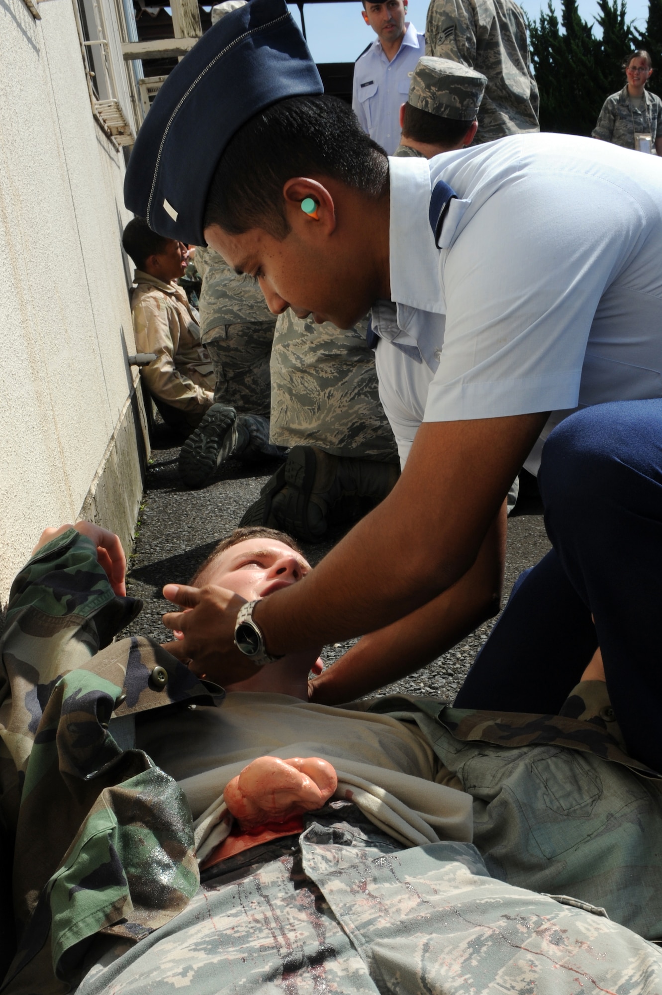 U.S Air Force 1st Lt. Dipta Kazi, right, 35th Logistics Readiness Squadron material management flight commander, provides self-aid buddy care to a role player with a simulated abdominal injury after an explosion during an Emergency Management Exercise at Misawa Air Base, Japan, Sept. 17, 2012. The exercise tested the wing's response to a mass casualty event, accountability procedures and response to an increased terrorist threat as part of the 35th Fighter Wing's Combined Unit Inspection. (U.S. Air Force photo by Airman 1st Class Kia Atkins/Released)