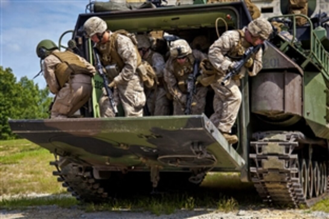 Marines dismount from an amphibious assault vehicle while performing a direct action raid on an urban terrain facility during pre-deployment training on Fort Pickett, Va., Sept. 8, 2012.