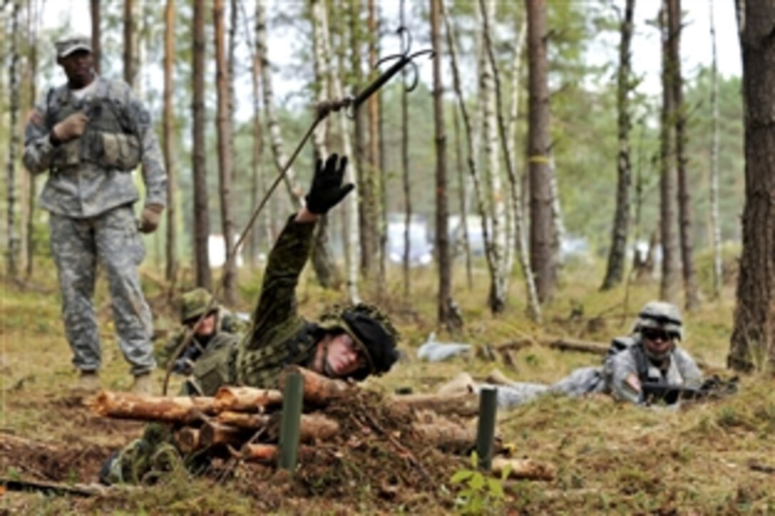 An Estonian soldier throws a grappling hook at a testing lane during the U.S. Army Europe's Expert Field Medical Badge competition in Grafenwoehr, Germany, Sept. 13, 2012.
