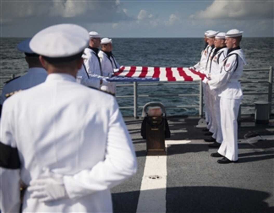 Members of the U.S. Navy Ceremonial Guard hold an American flag over the remains of Apollo 11 astronaut Neil Armstrong during a burial at sea service aboard the guided-missile cruiser USS Philippine Sea (CG 58) in the Atlantic Ocean on Sept. 14, 2012.  Armstrong, the first man to walk on the moon during the 1969 Apollo 11 mission, died Saturday, Aug. 25.  He was 82.  