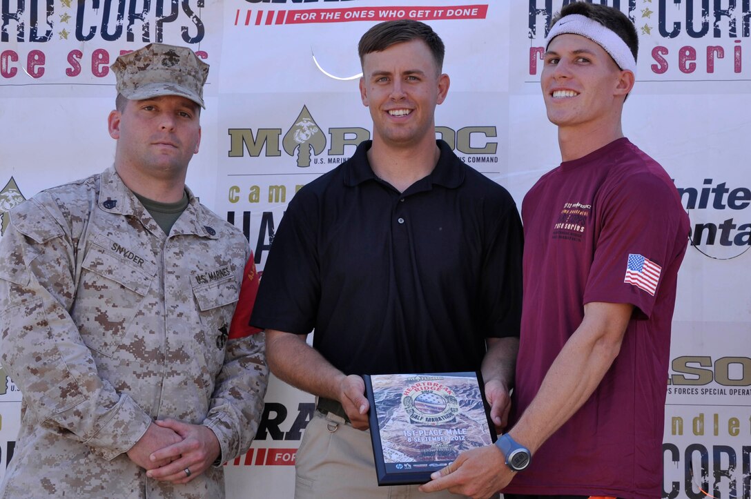 Cpl. Samuel C. Brandt, a radio operator with 1st Intelligence Battalion, receives an award for being a first place finisher during the Heartbreak Ridge Half Marathon at Camp Pendleton's 43 Area Parade Deck, Spet. 8.
